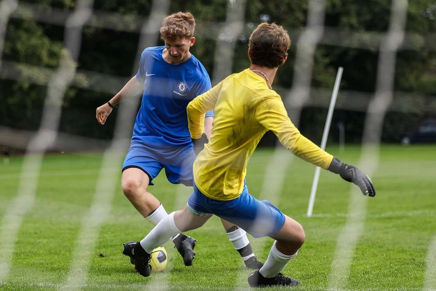 Junge dribbelt am Torwart vorbei