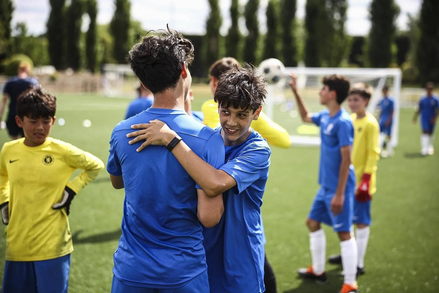 Boys from different nationalities making friends on football camp