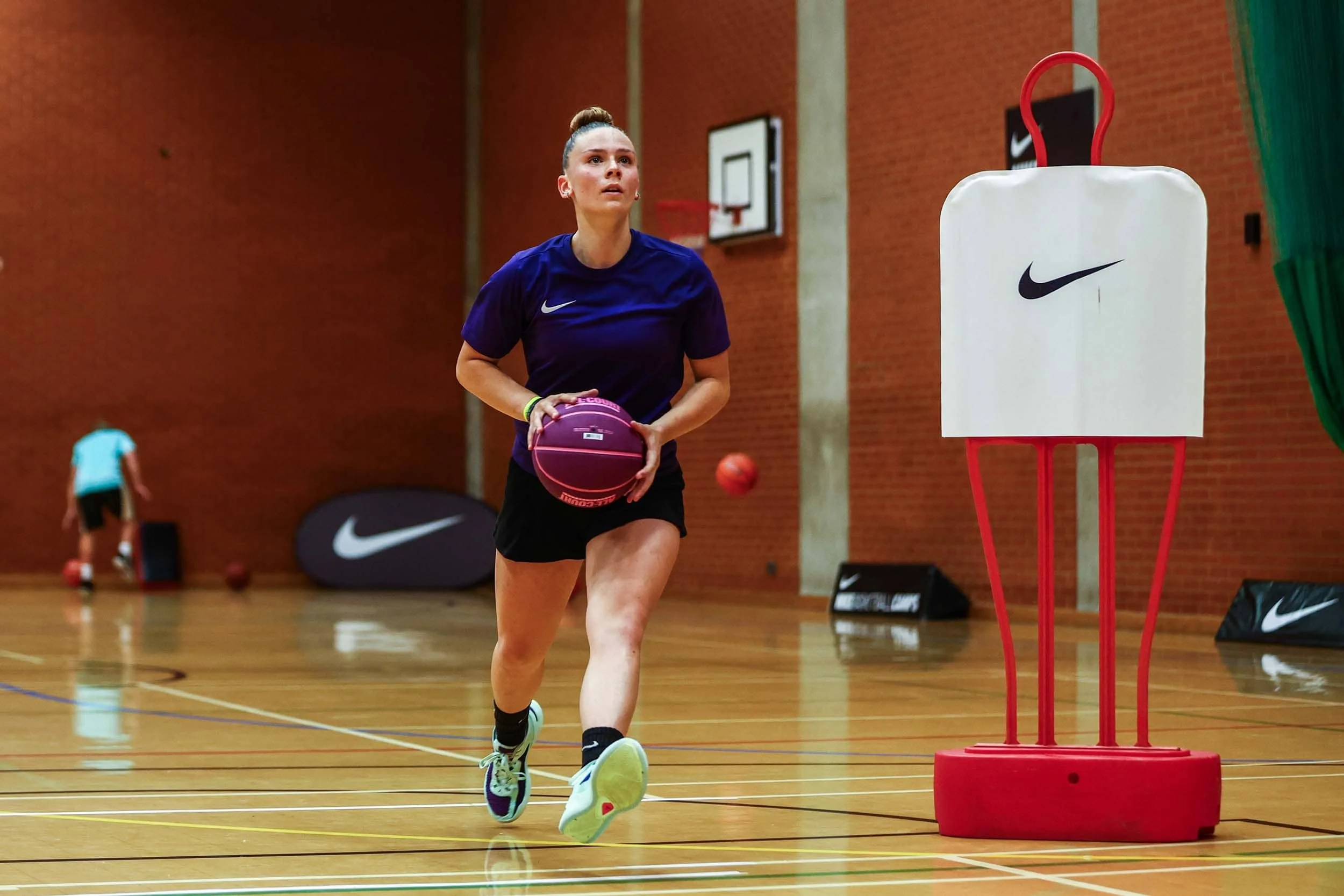 Jugadora de baloncesto durante un entrenamiento en un campamento de baloncesto.