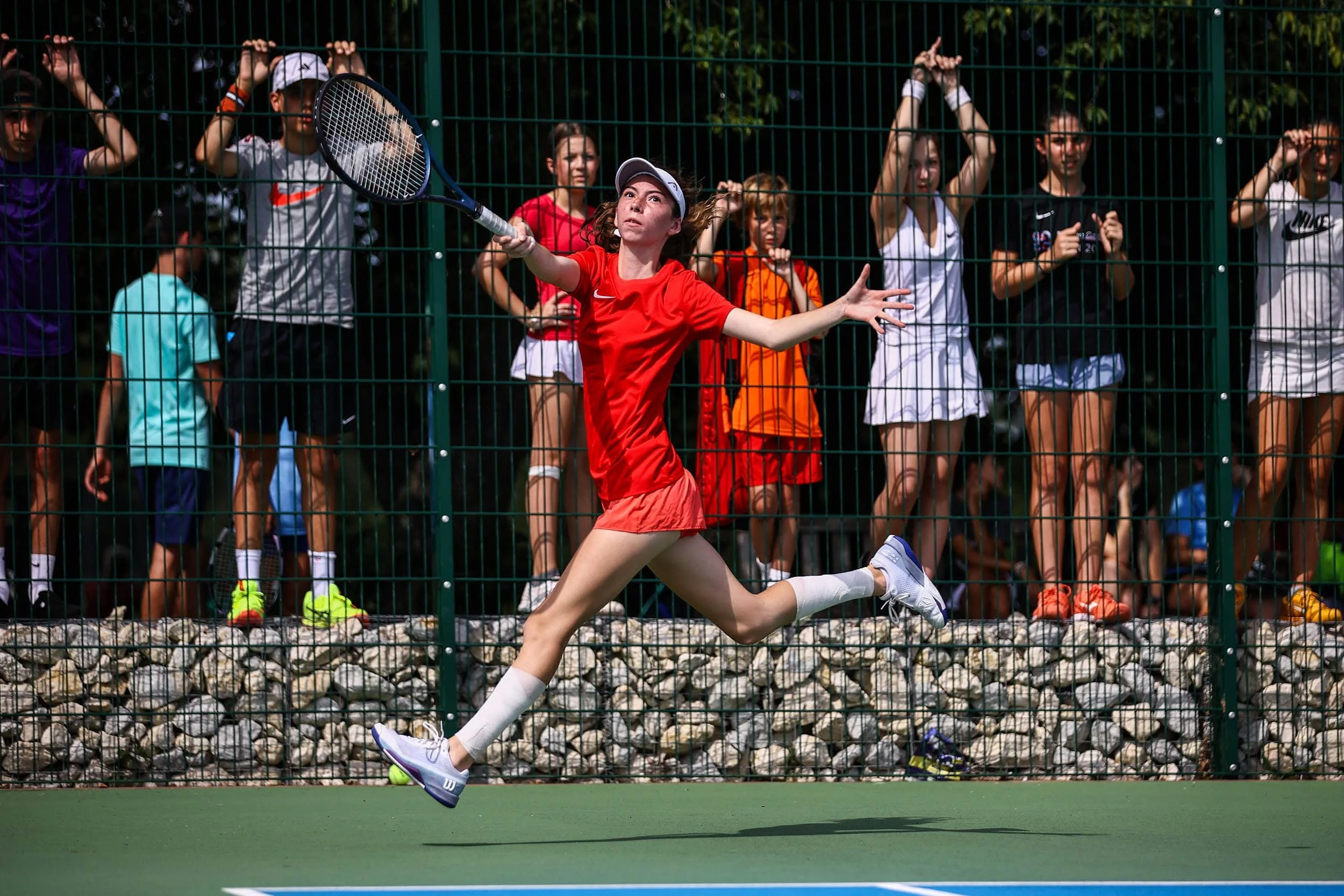Junge beim Aufschlag während eines Spiels im Tenniscamp
