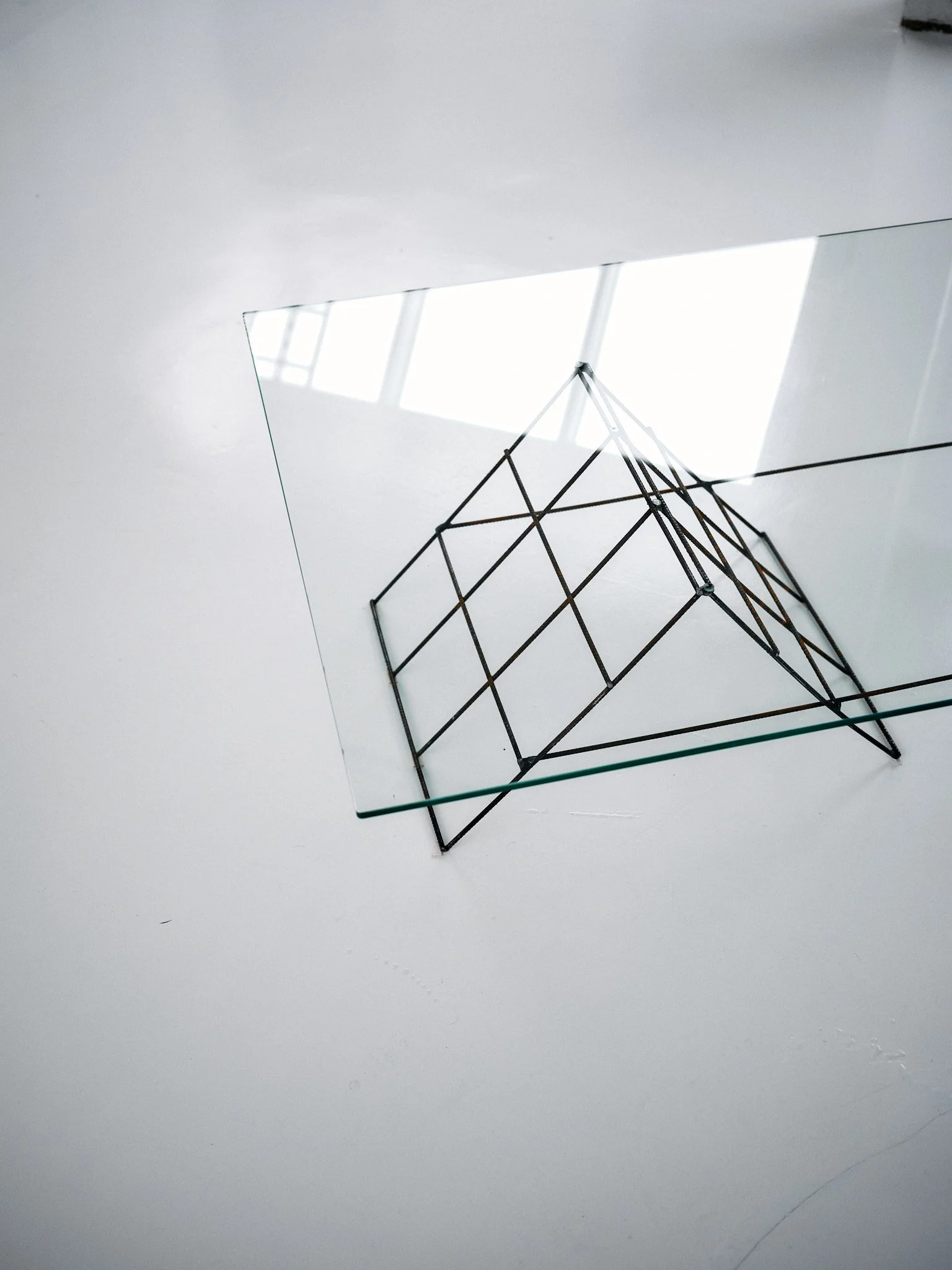 Lasinen sohvapöytä, jossa geometriset metalliset jalat