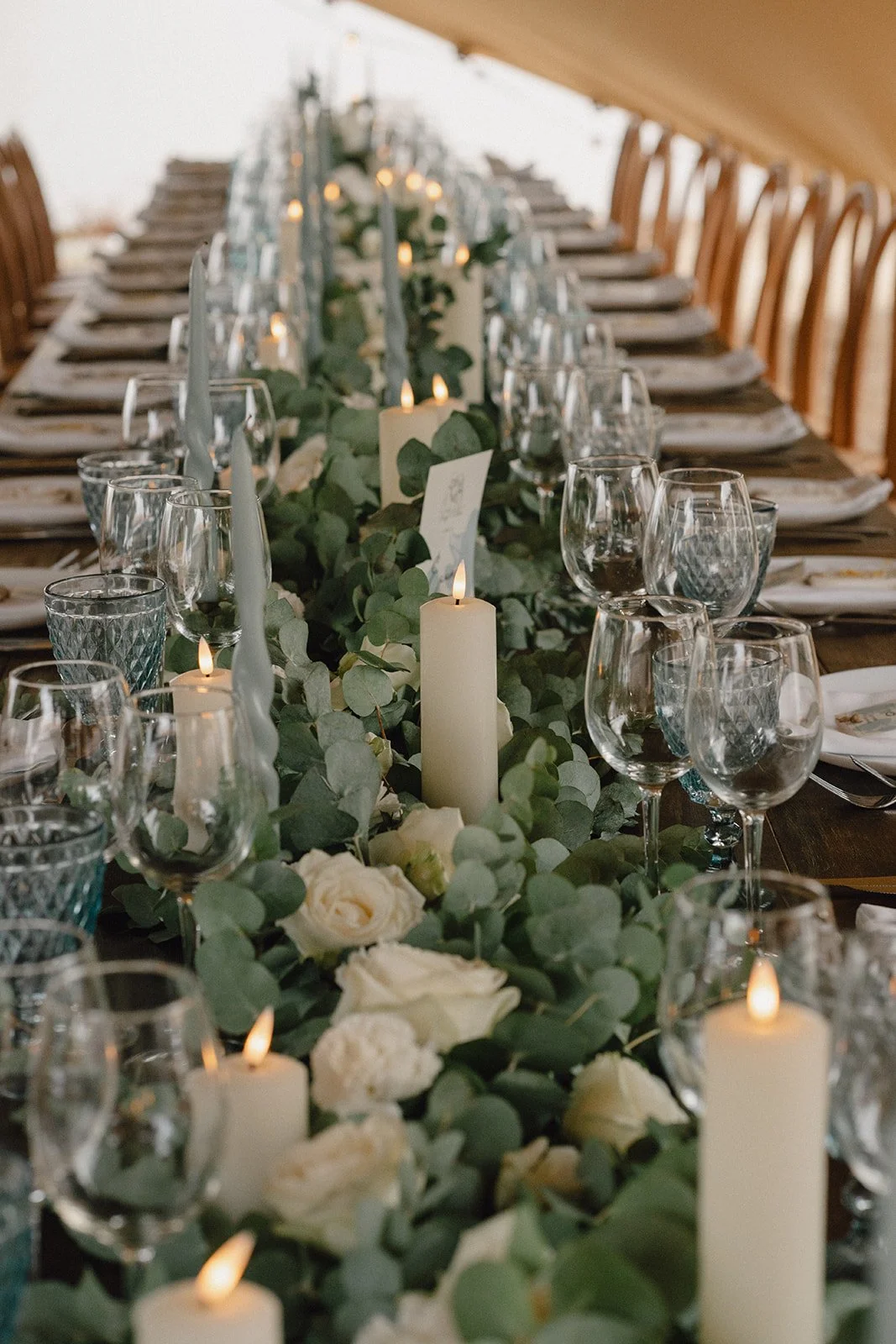 Photo décoration de table, mettant en avant le centre de table, feuilles d'eucalyptus et bougies 