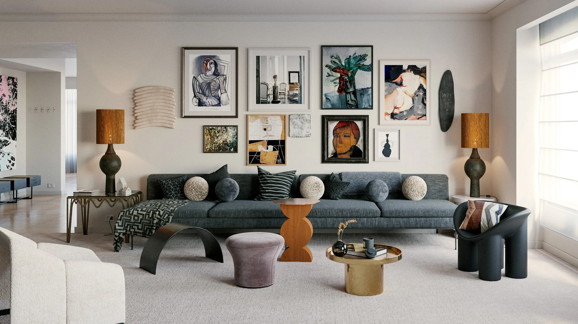 Living room with a dark gray sofa, patterned throw pillow, and round plush decorative objects, with a gallery wall of various art pieces and photographs above. Two lamps with brown shades flank the sofa, and there are multiple small tables with decor