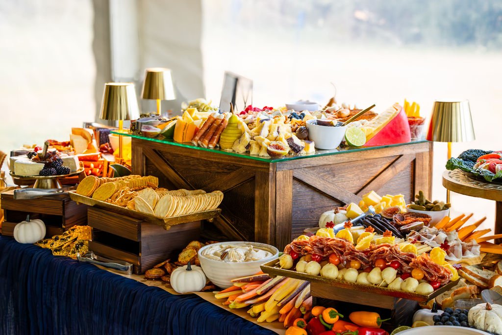 Charcuterie table display with various meats, cheeses, vegetables, dips and lights