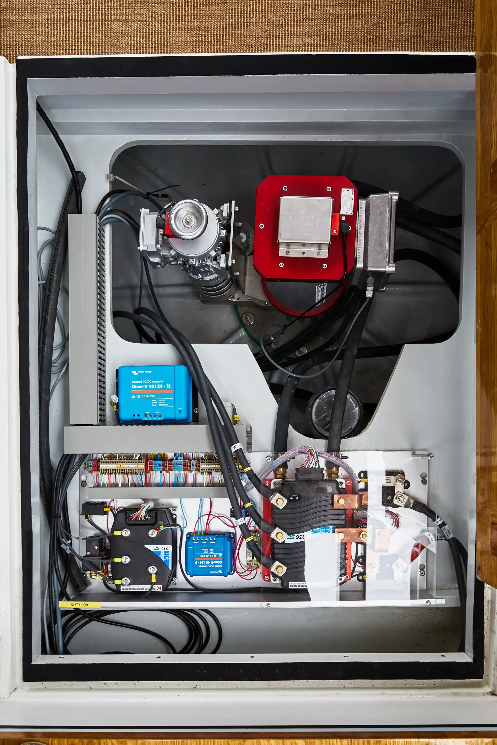 Innenseite eines technischen Gehäuses mit verschiedenen elektrischen Komponenten, Kabeln und Schaltungen.