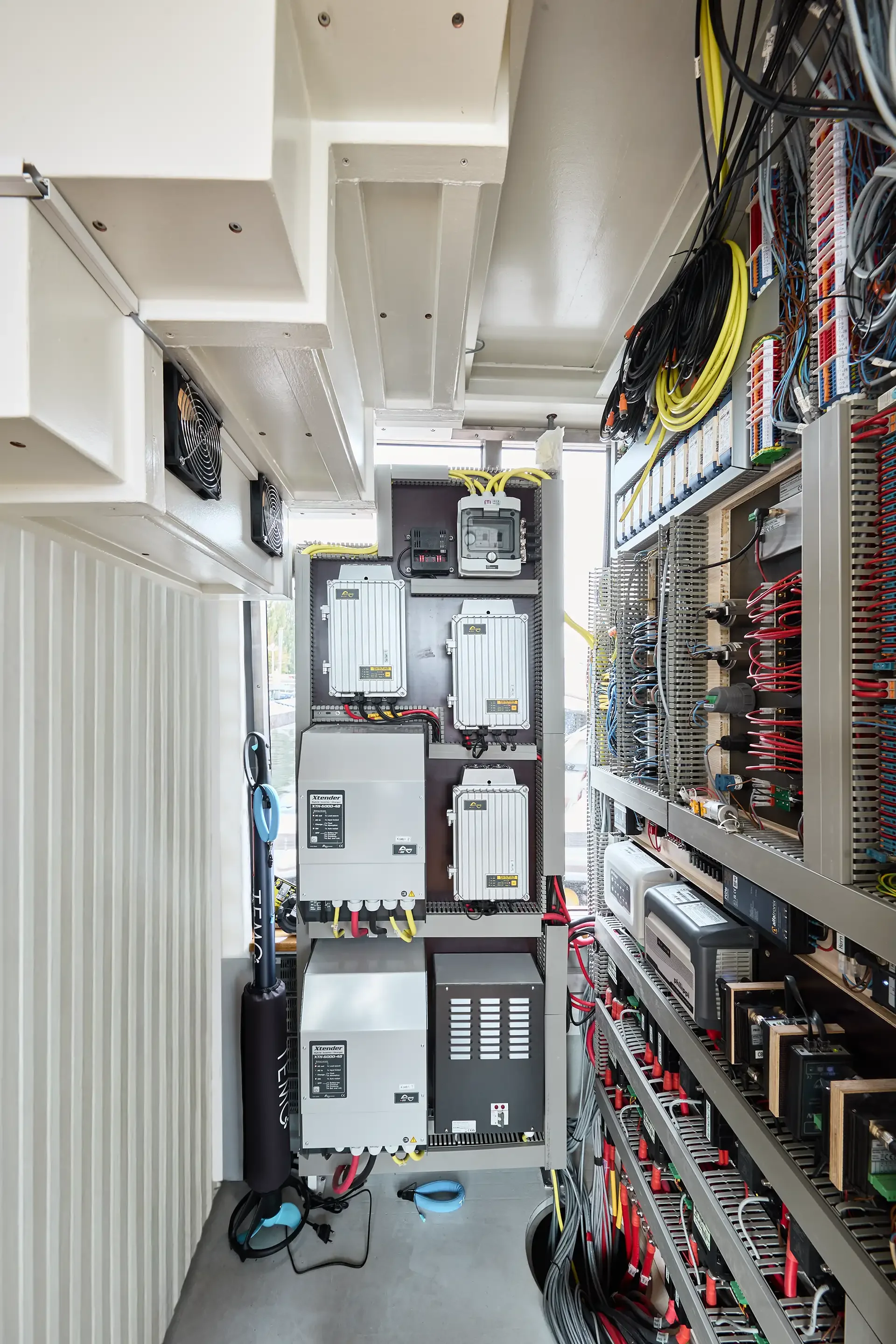 Innenansicht eines Elektroschranks mit verschiedenen Komponenten, Kabeln und Steuerungen.