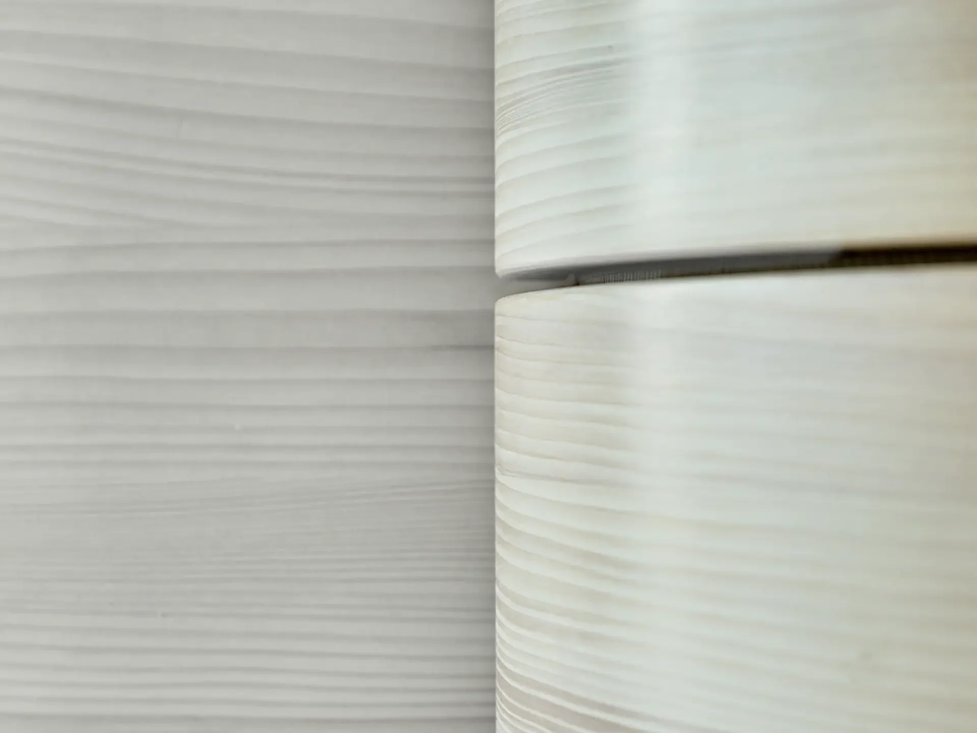 Nahaufnahme eines aufgeschlagenen Buches oder Notizbuchs, das weiße, linierte Seiten zeigt.