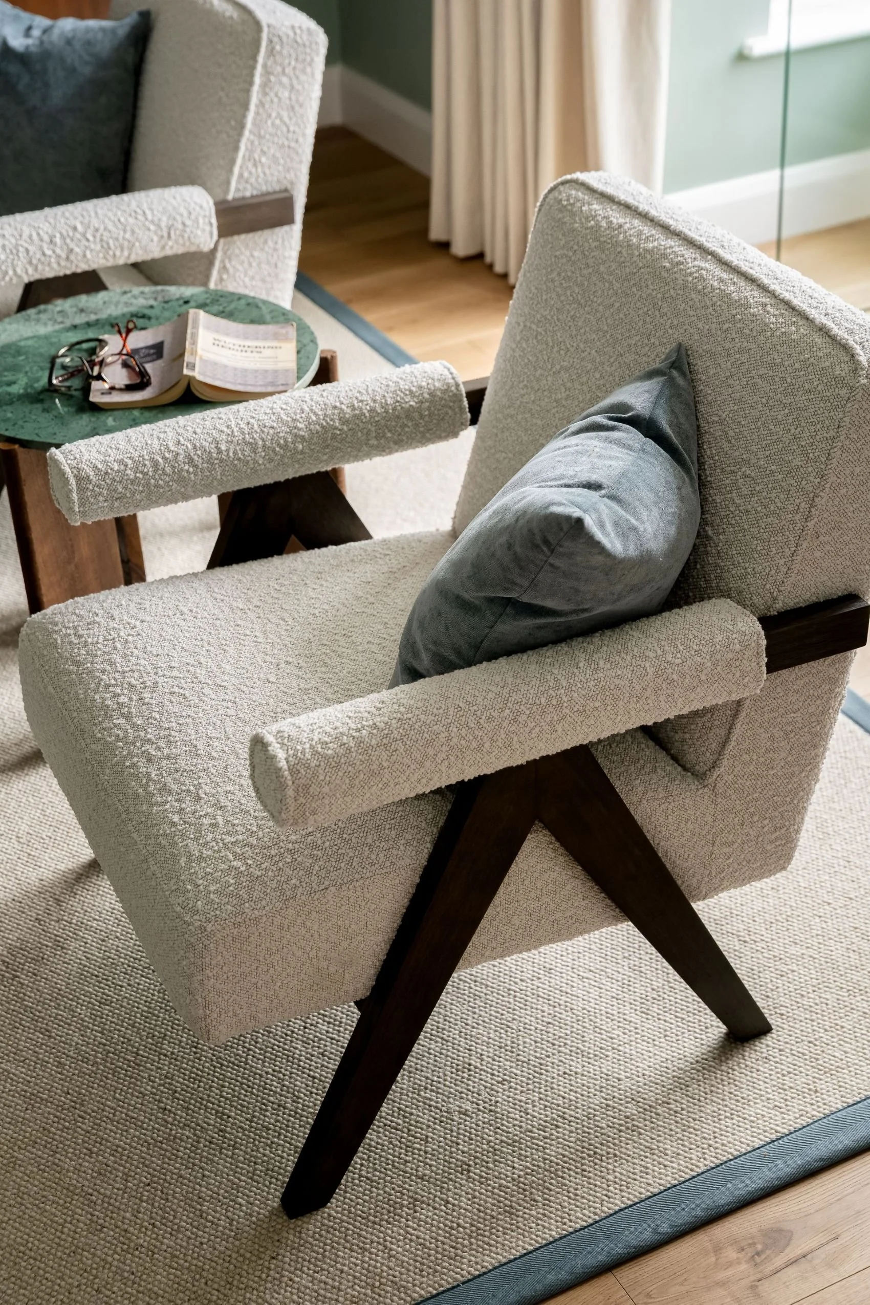 Modern sitting room with textured armchairs, blue cushions and full-length curtains by South Hill Studio in Kilkenny.