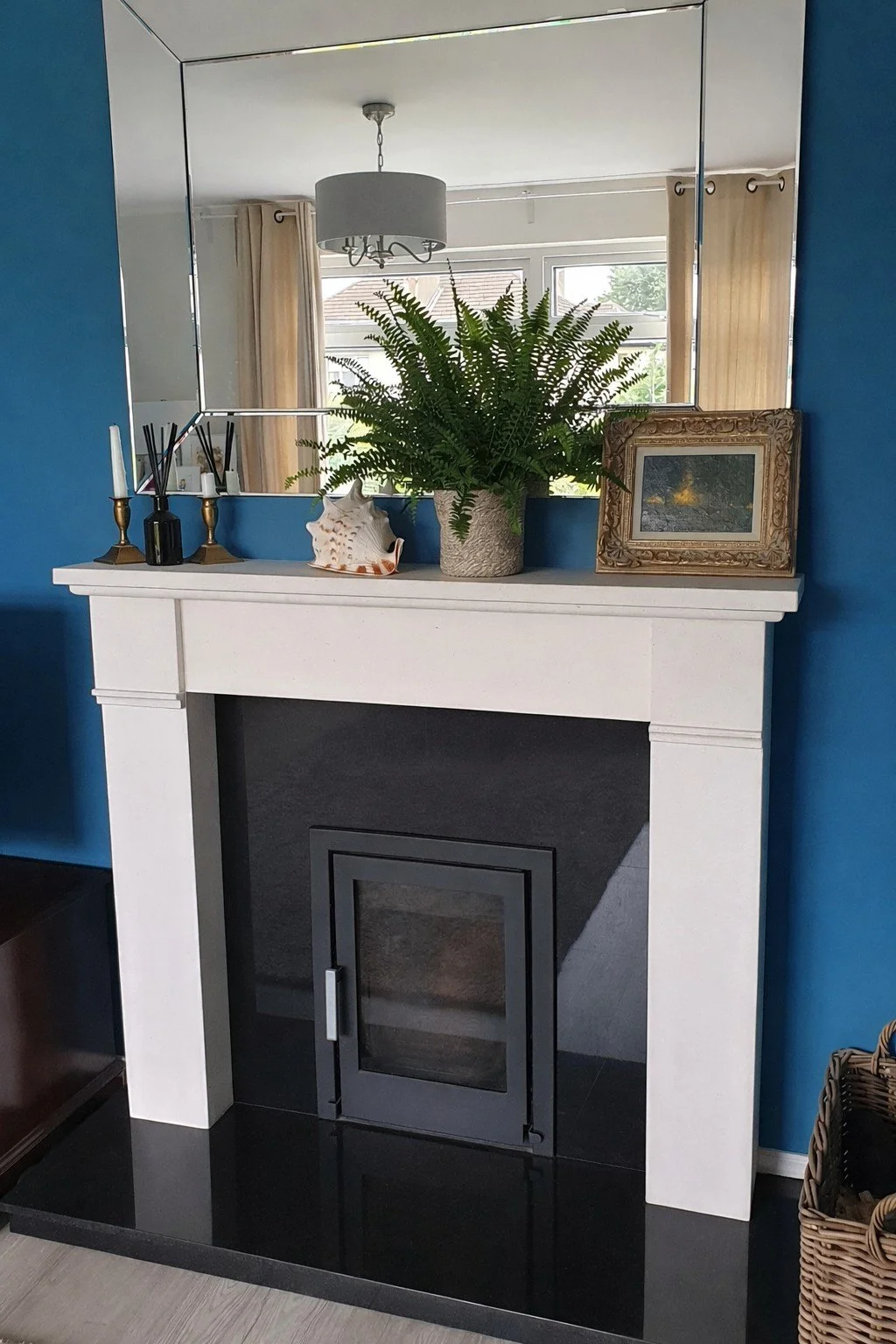 Styled fireplace with mirror and wall lights creating a focal point in a Dundrum townhouse sitting room