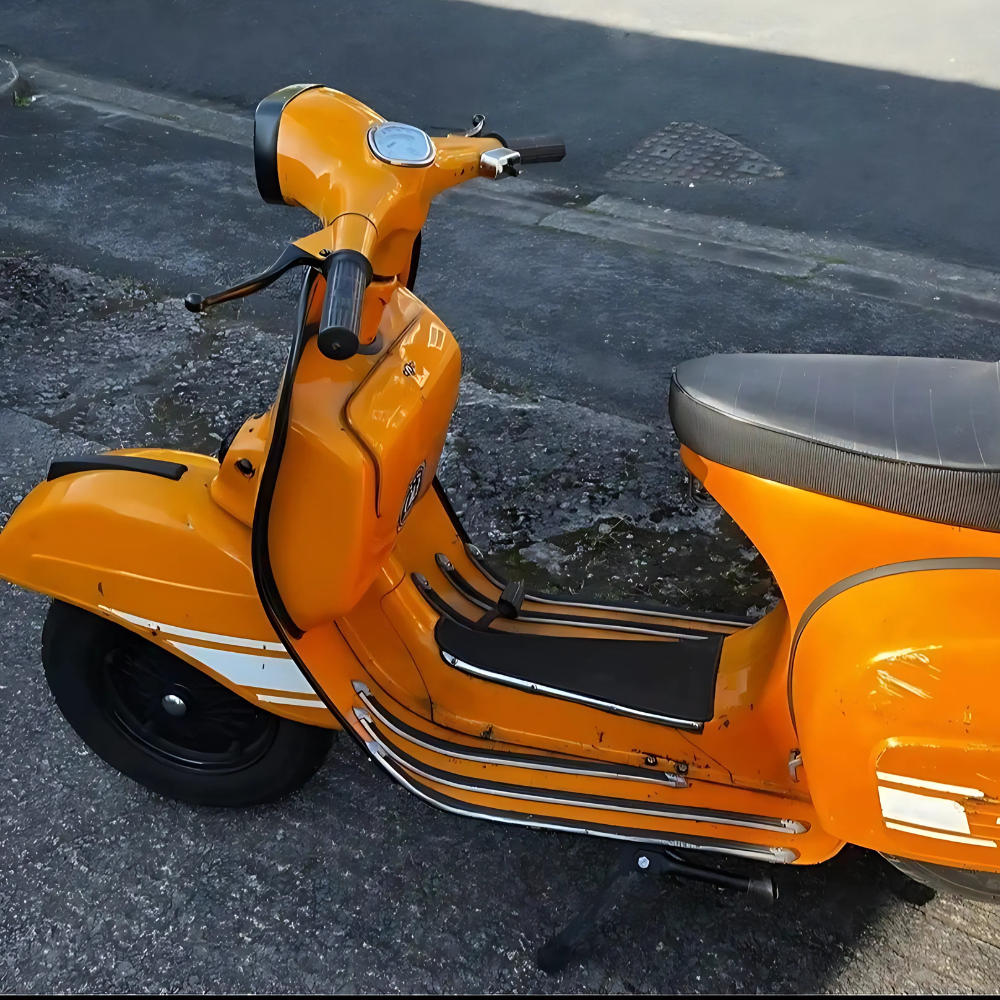 Orange vintage scooter parked on rough asphalt.