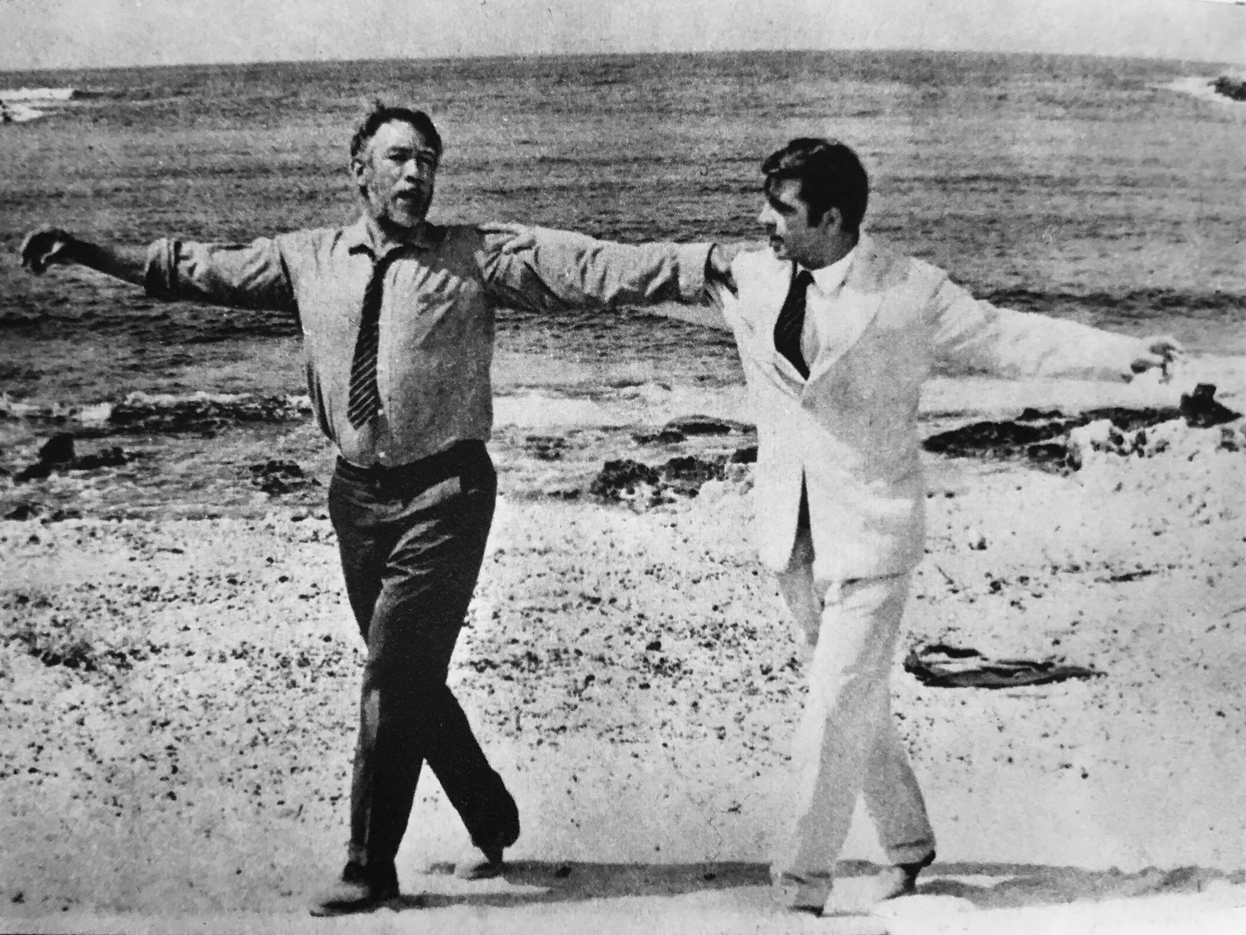 Vintage black and white still from movie Zorba the Greek (1966) of two men dancing on beach, Kinema Junpo