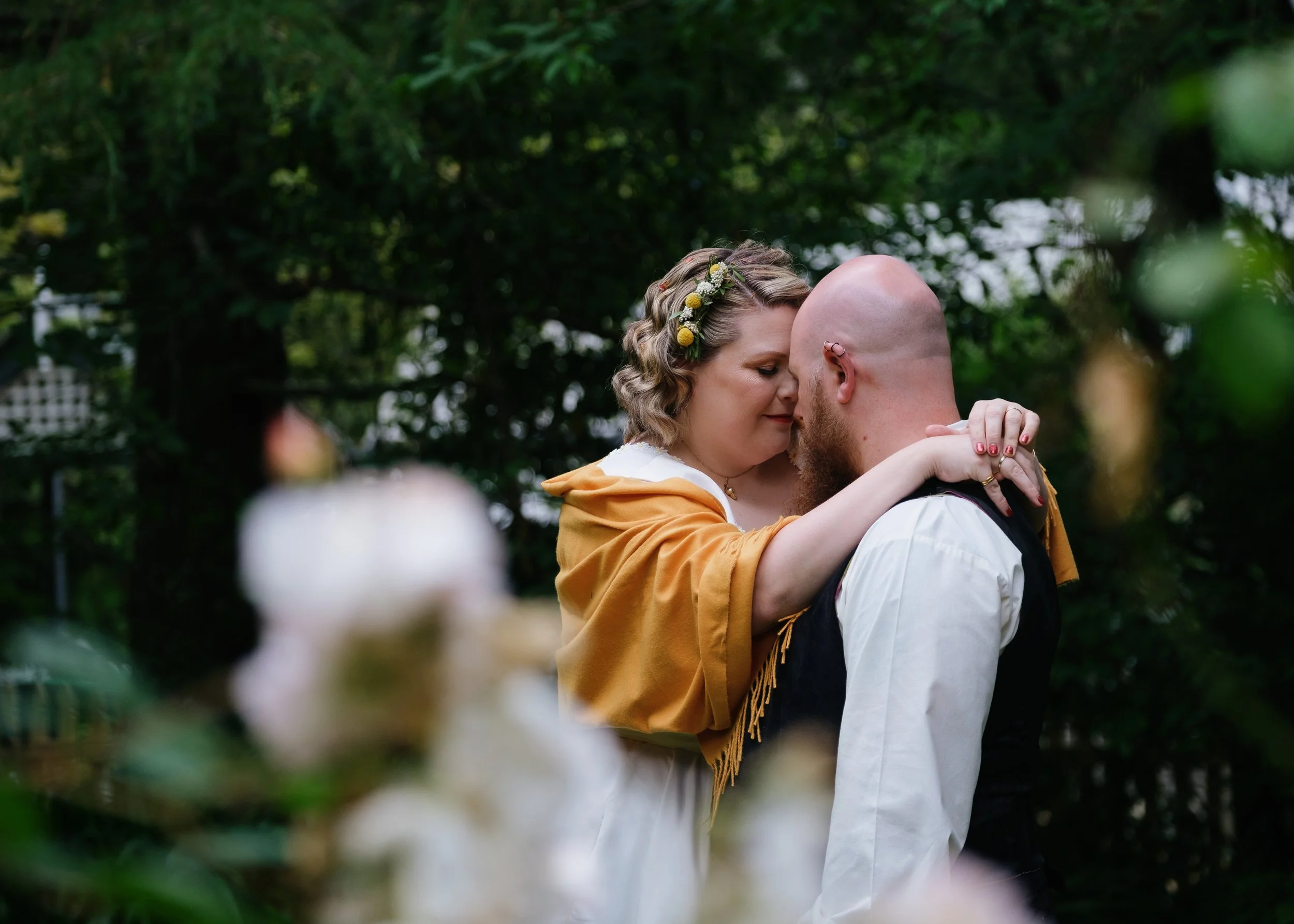 A tender moment between two newlyweds, surrounded by lush greenery — a timeless image from a romantic Blue Mountains elopement.