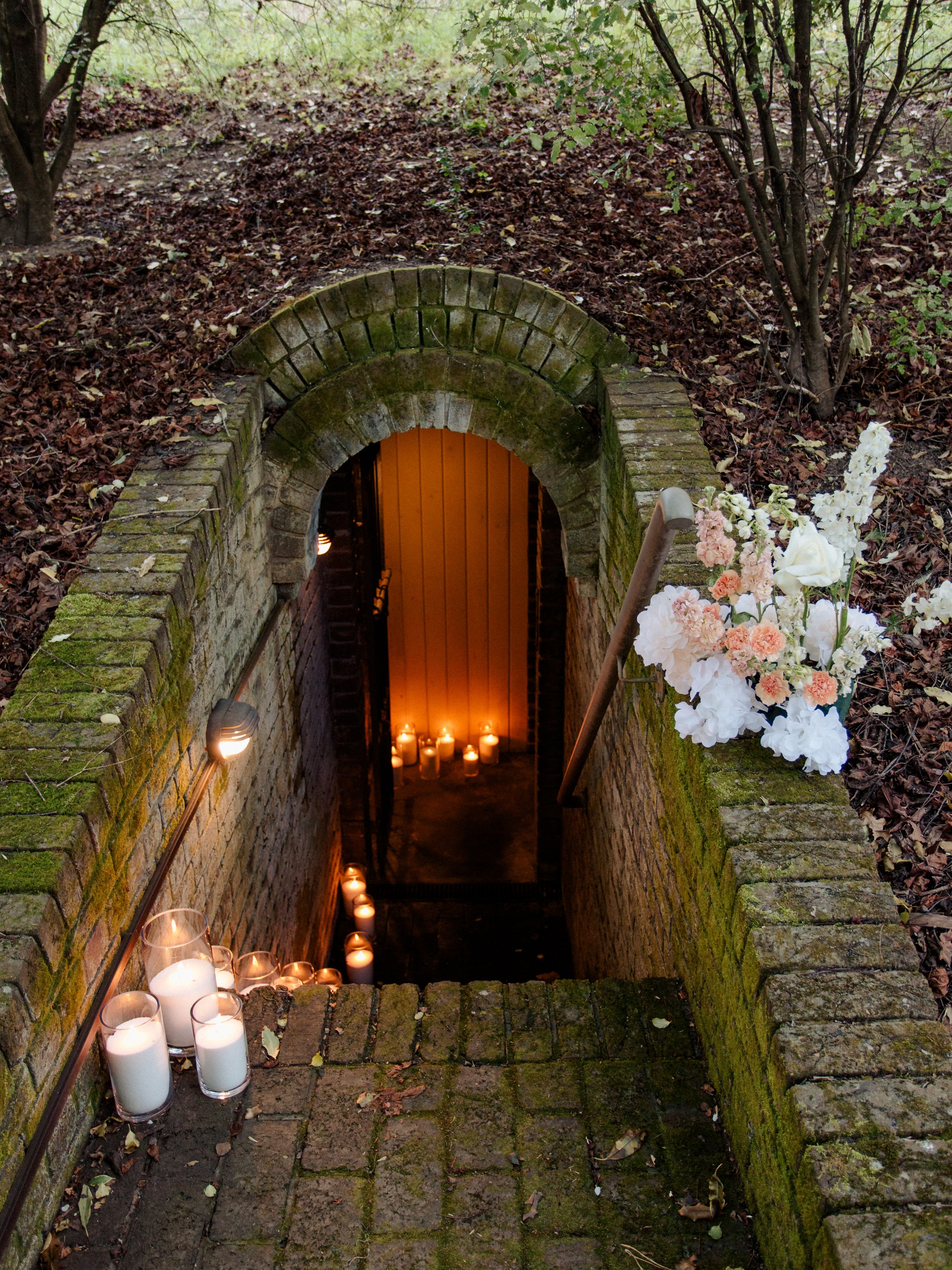 A candlelit brick staircase surrounded by trees and flowers creates an enchanting Blue Mountains elopement backdrop.