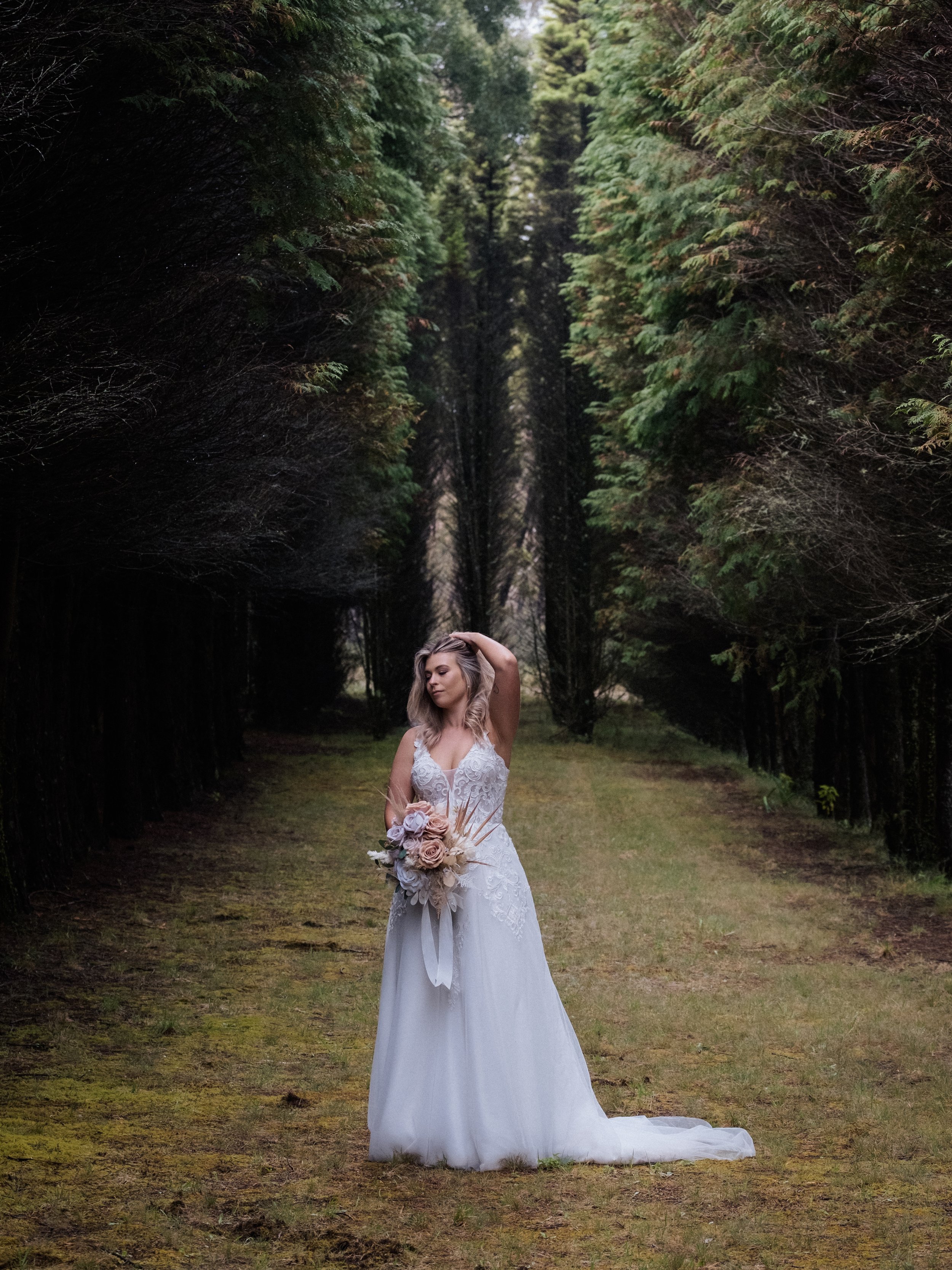 A couple shares a tender kiss at night beneath glowing rhododendron blooms during their Blue Mountains elopement.