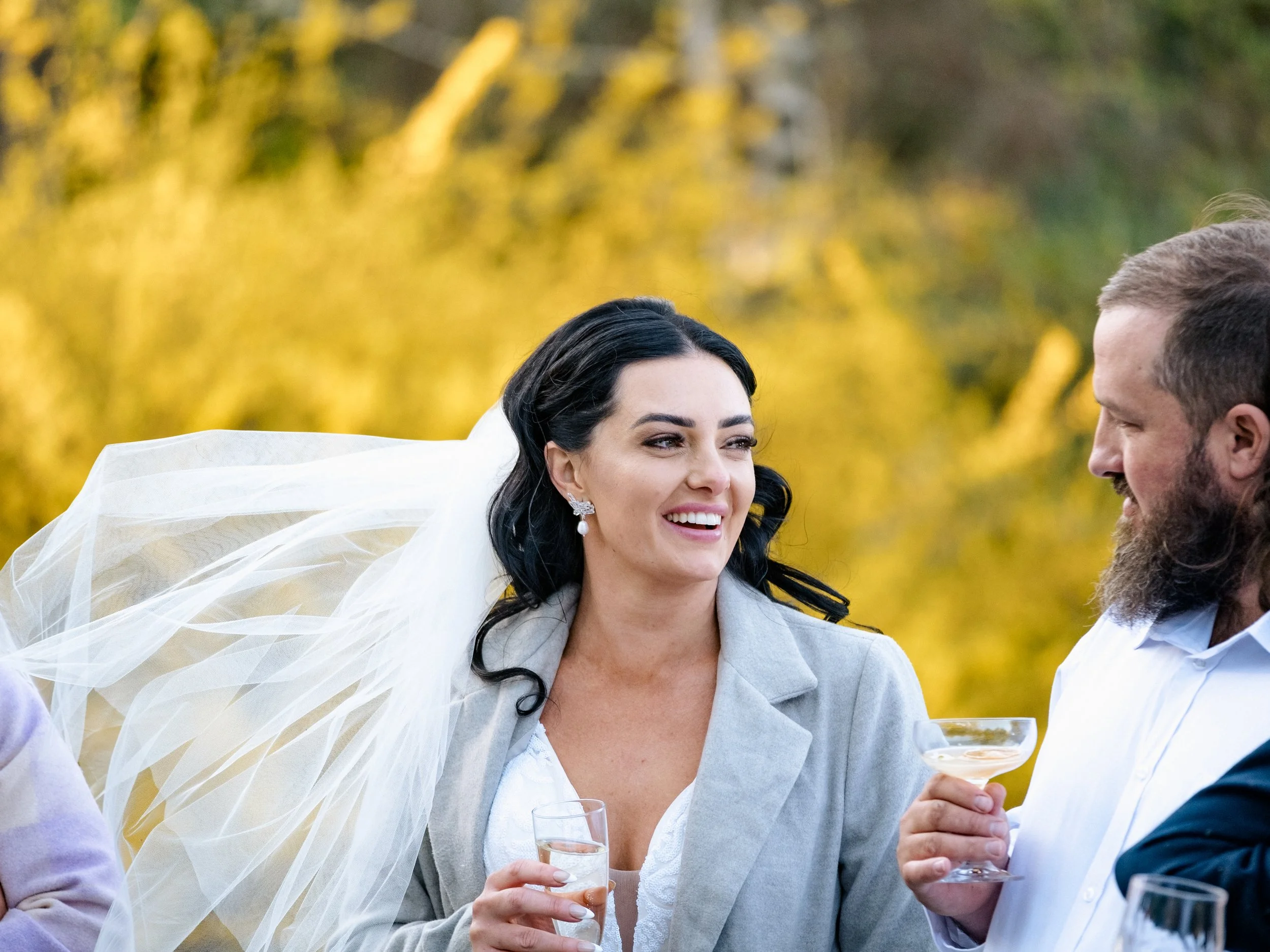 A bride and groom laugh together at their outdoor Blue Mountains elopement, celebrating under golden autumn leaves.