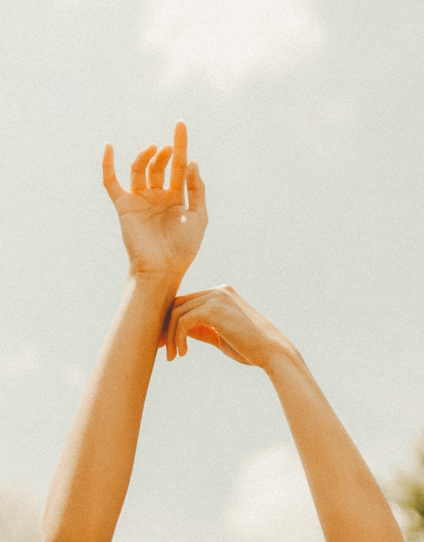 Due mani che si muovono contro un cielo chiaro, una con il pollice verso l'alto e l'altra con le dita che si incontrano.