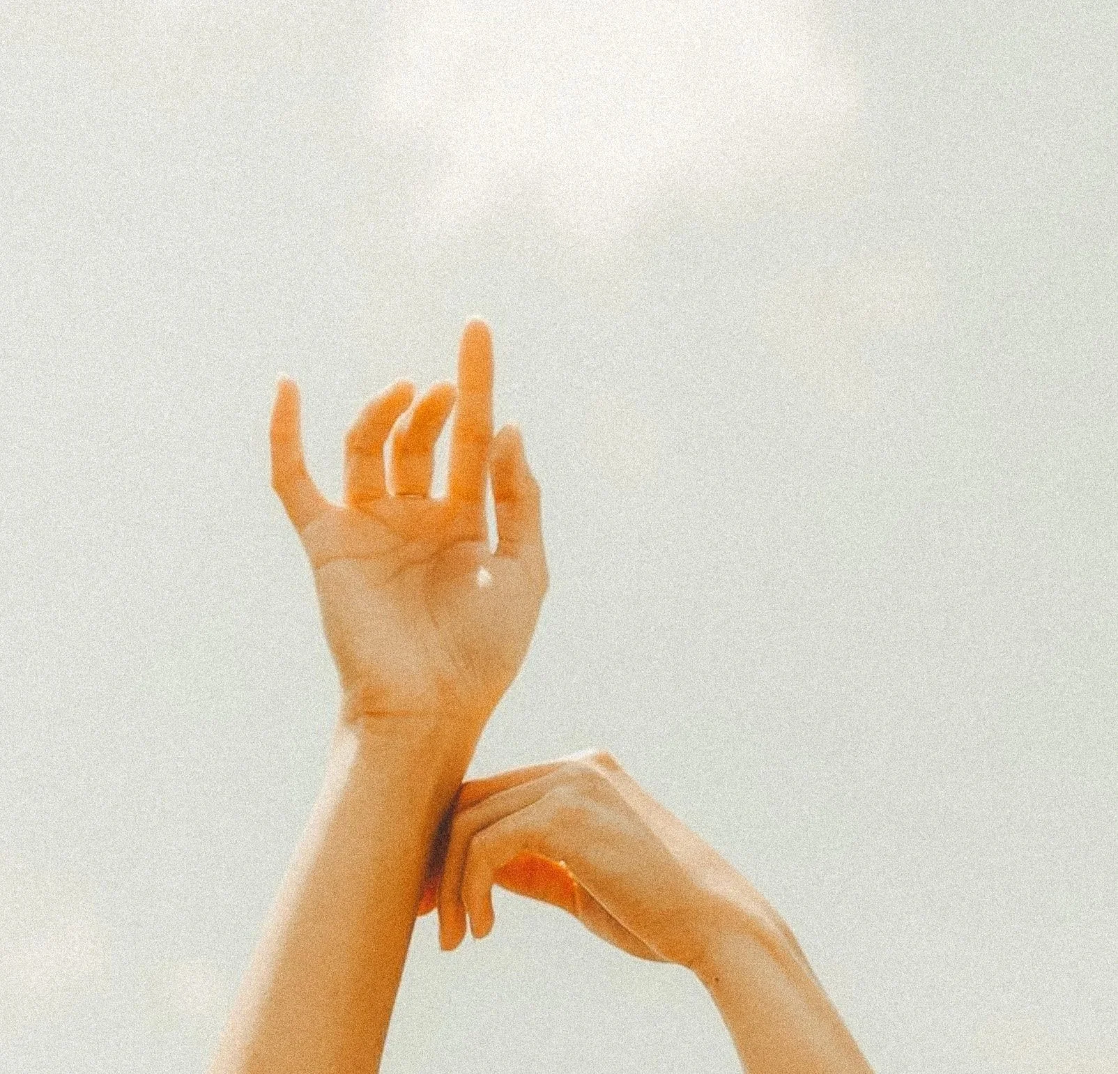 Due mani che si muovono contro uno sfondo neutro, una che forma un angolo con il pollice e l'indice, l'altra che si muove sotto.