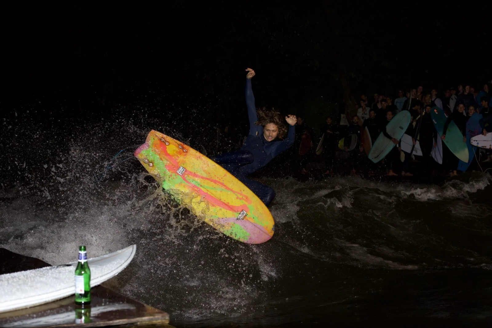 Luca Holy beim Rapid Jam auf dem Train mit FS Air Reverse und eine Flasche Bier auf einem Tisch im Vordergrund, während eine Gruppe von Menschen im Hintergrund sitzt.