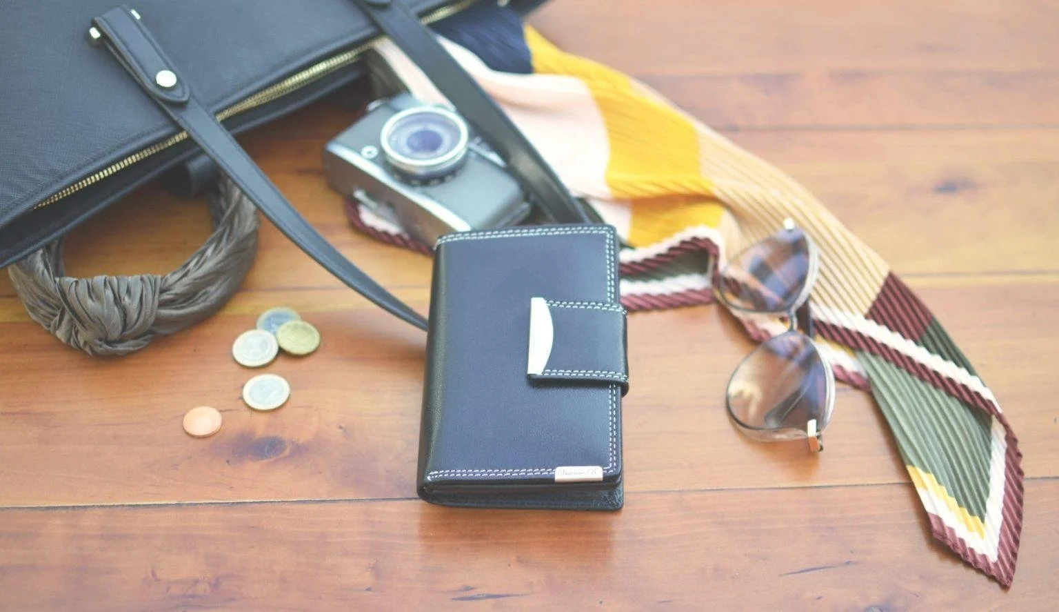 Leder-Geldbörse mit Accessoires auf Holztisch – Abrechnung nur für verkaufte Ware im fairen Kommissionssystem für stationäre Händler