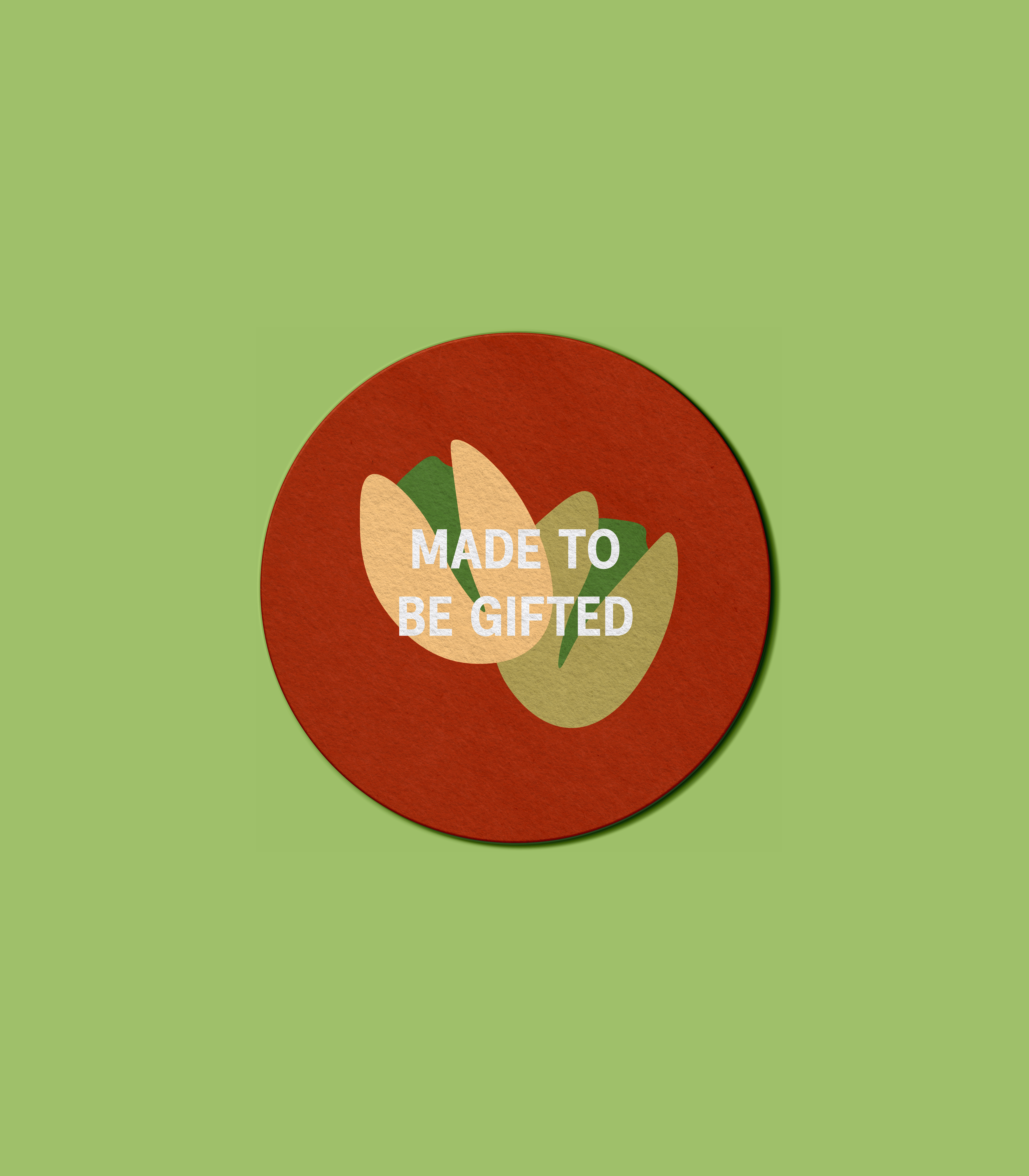 Round red badge with abstract illustrations of pistachio nuts and the white text 'Made to be gifted' in the center. designed by Abubakr Moolla Brand Designer from East London.