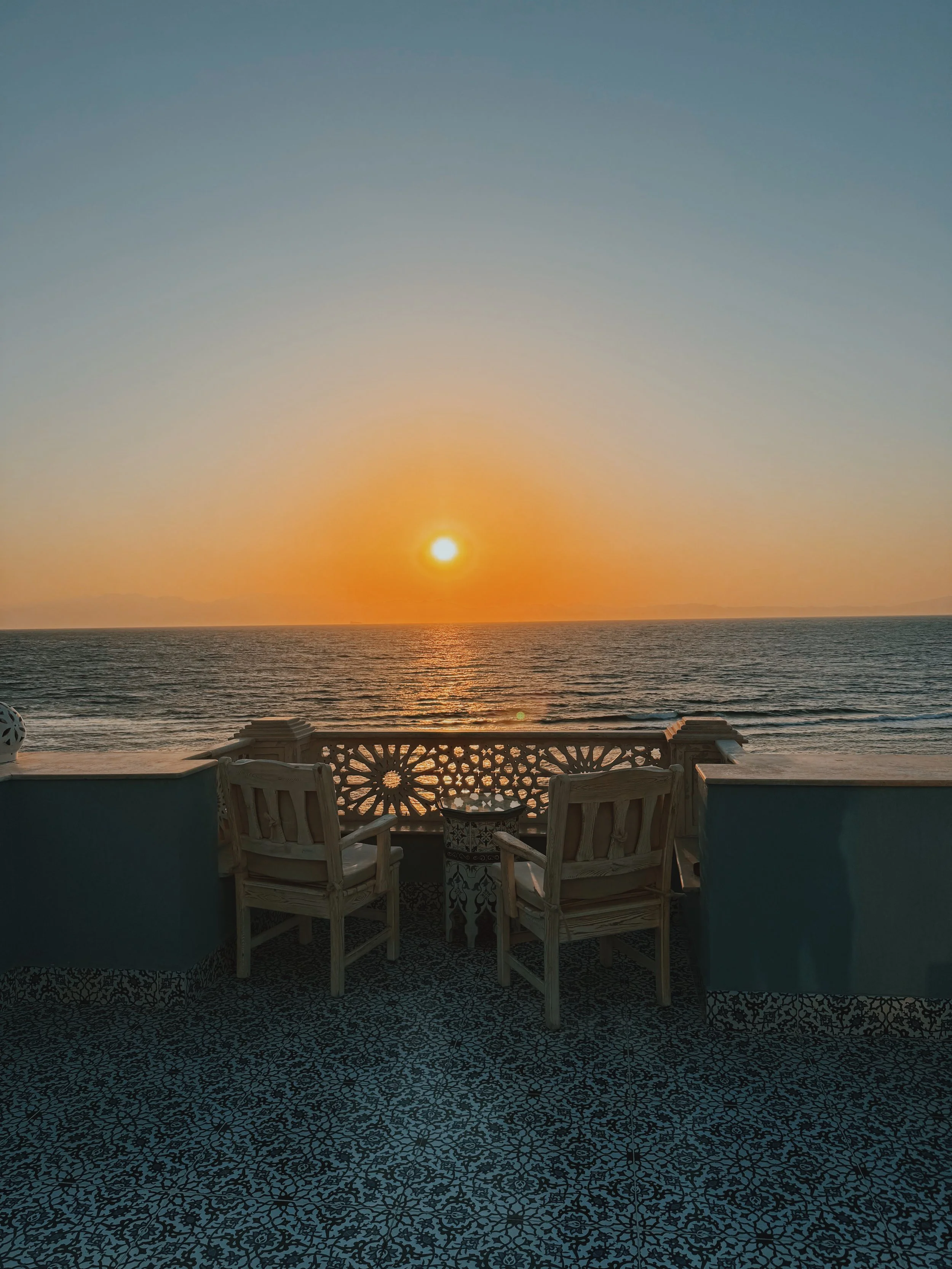 Two chairs facing the sunrise over the Gulf of Aqaba from the rooftop of Nour Boutique Hotel in Dahab.