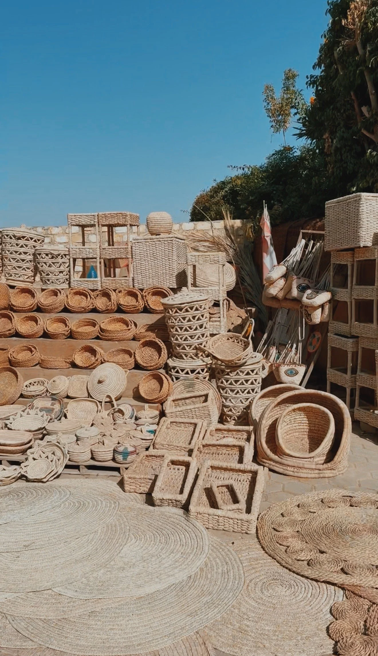 Handwoven palm-fiber baskets, lidded pots and round rugs displayed in the sun in Tunis village, Faiyum.