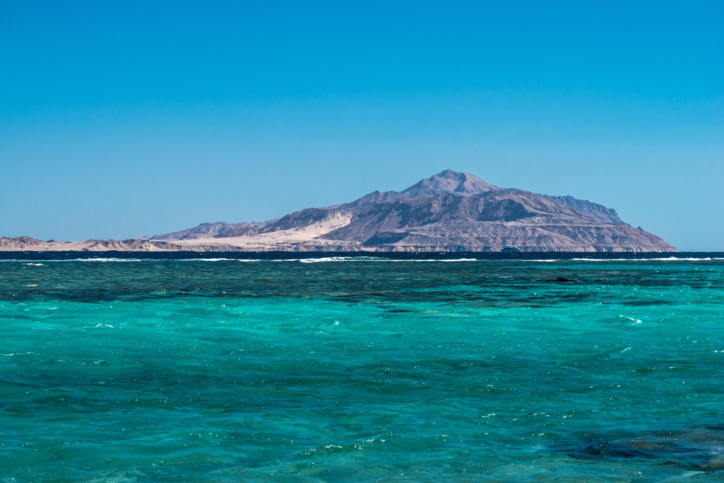 Tiran Island rising beyond the turquoise reef waters of the Red Sea off Sharm El Sheikh.