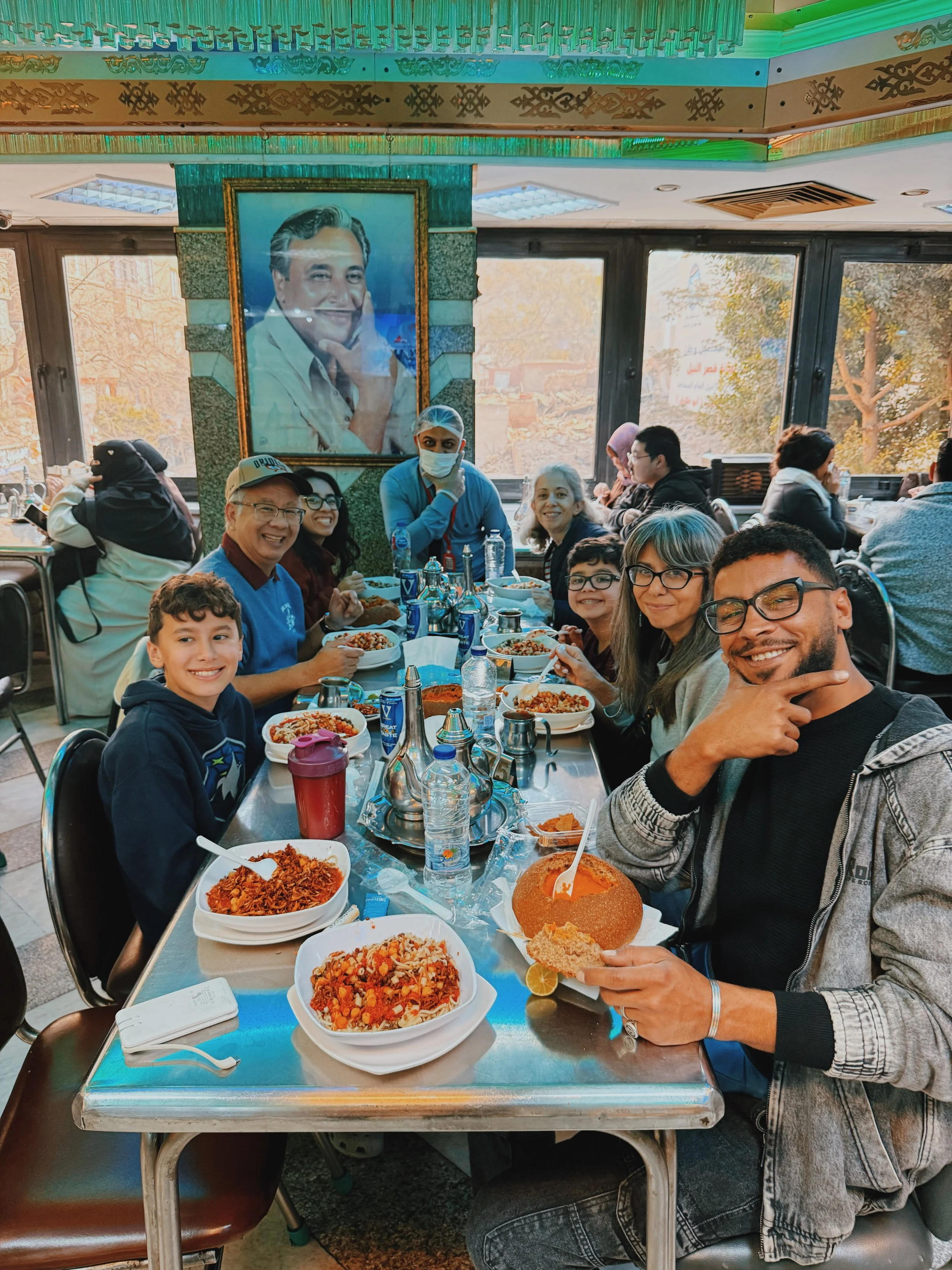 Mostafa of Takemet Tours sharing a traditional koshary lunch with a family of guests at Abou Tarek in Cairo