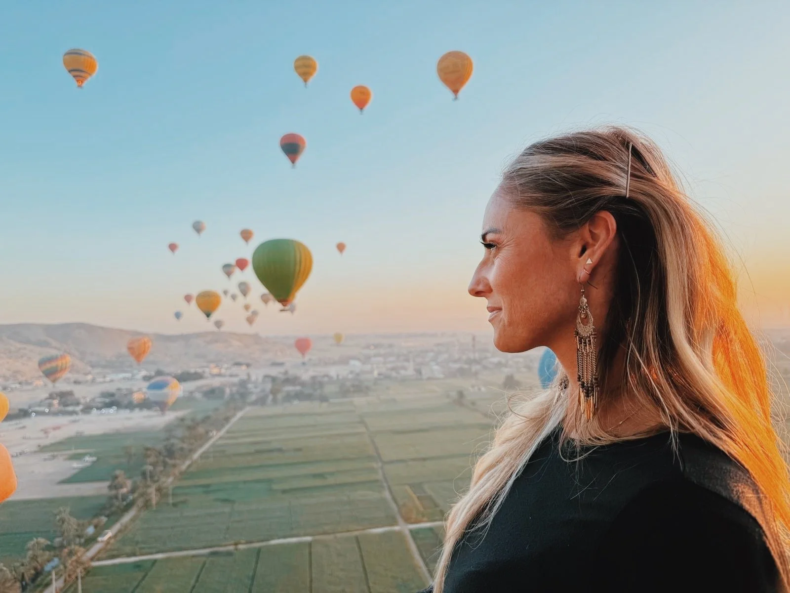 Jennifer watching dozens of hot air balloons rise over the green fields of Luxor’s West Bank at sunrise.