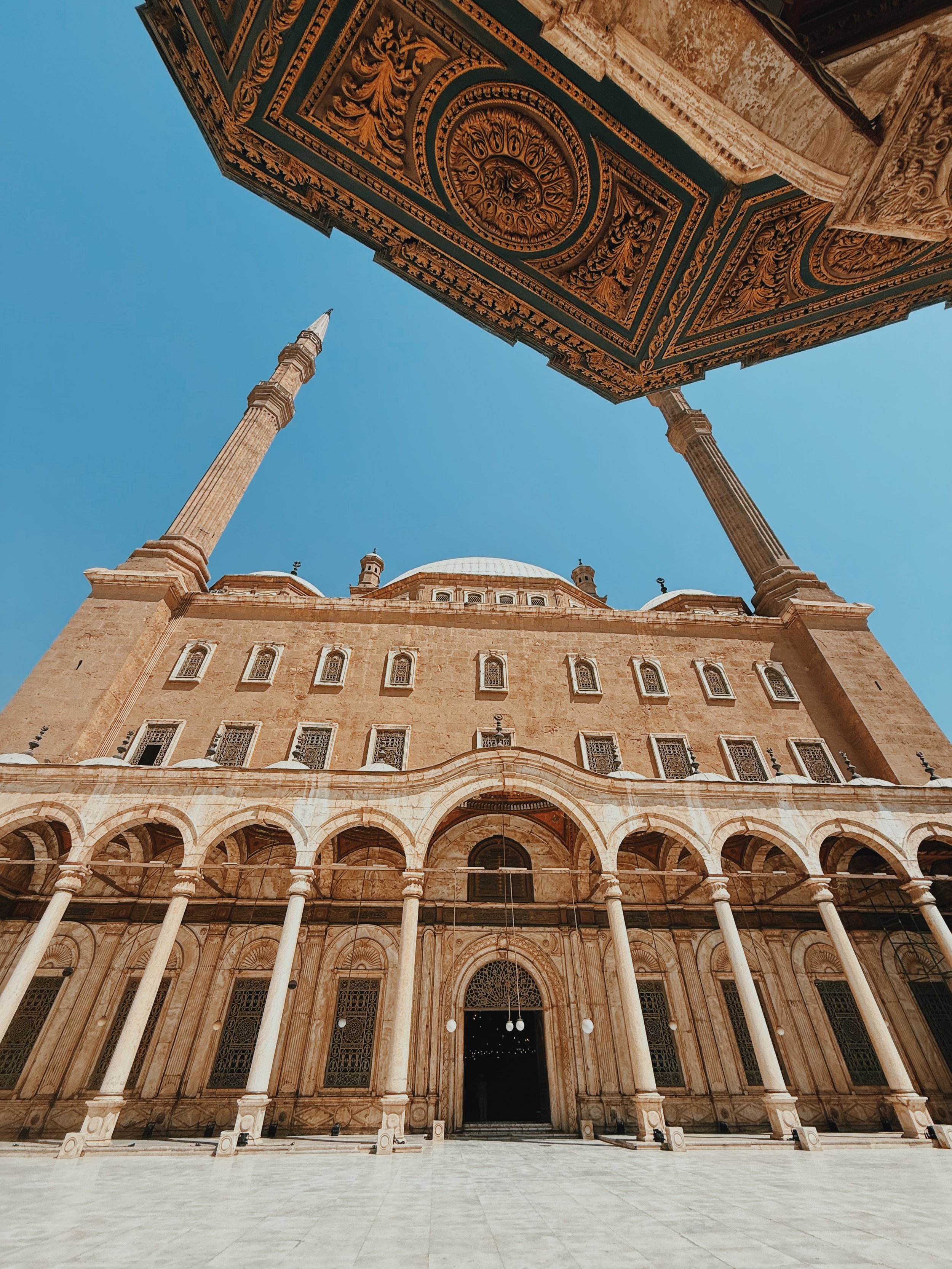 Looking up at the domes and minarets of the Mosque of Muhammad Ali from its courtyard at the Cairo Citadel.