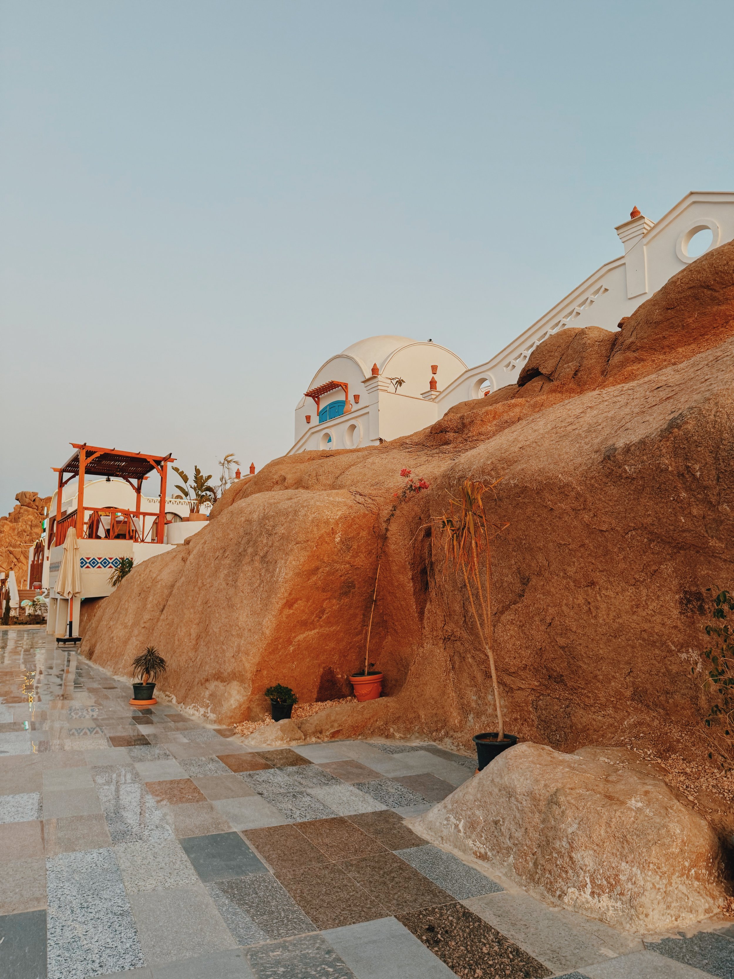 White Nubian-style domes and an orange pergola built into the granite rocks of an Aswan hotel.