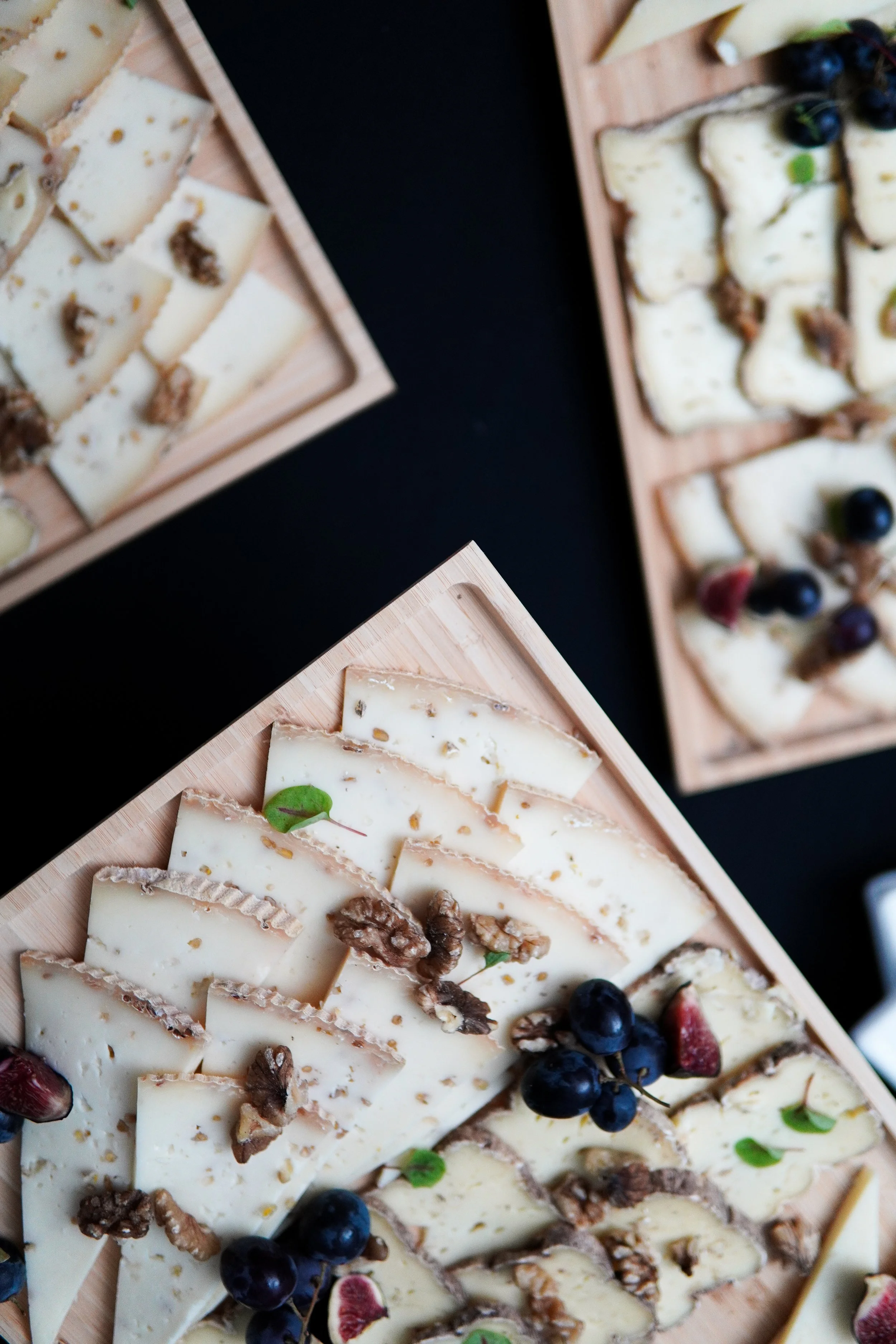Plate de fromages avec noix, raisins, figues et feuilles de basilic.
