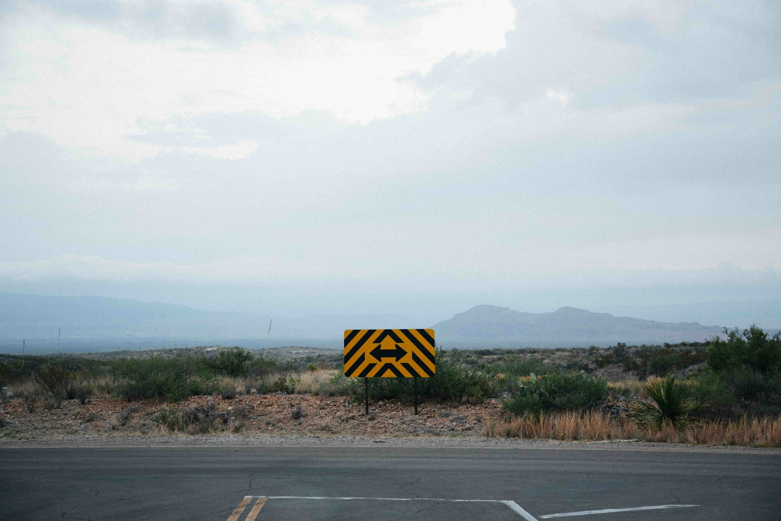 Dead-end road sign with arrows pointing left and right representing uncertainty and life direction decisions