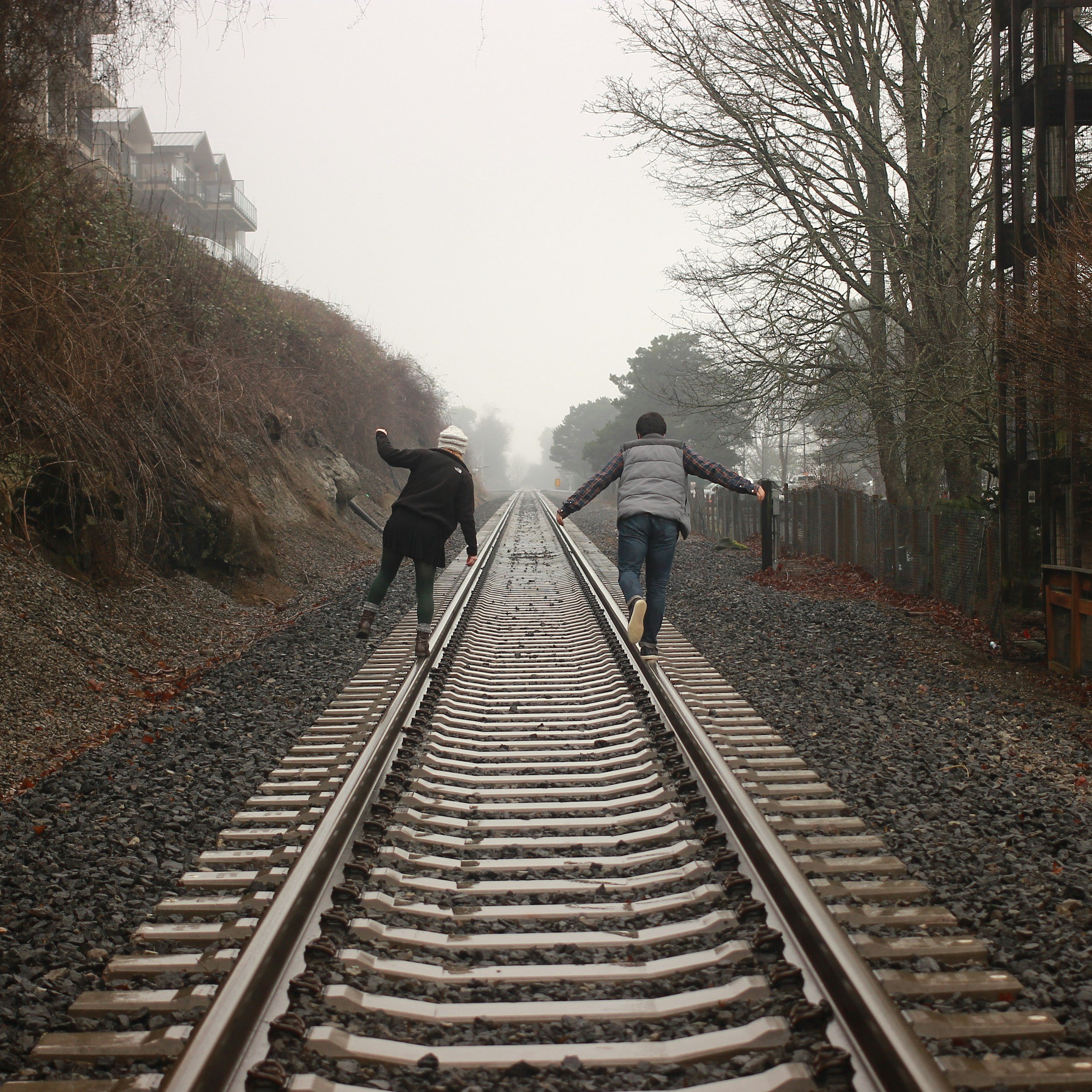 Couple running together down a railroad track representing progress and moving forward in a relationship