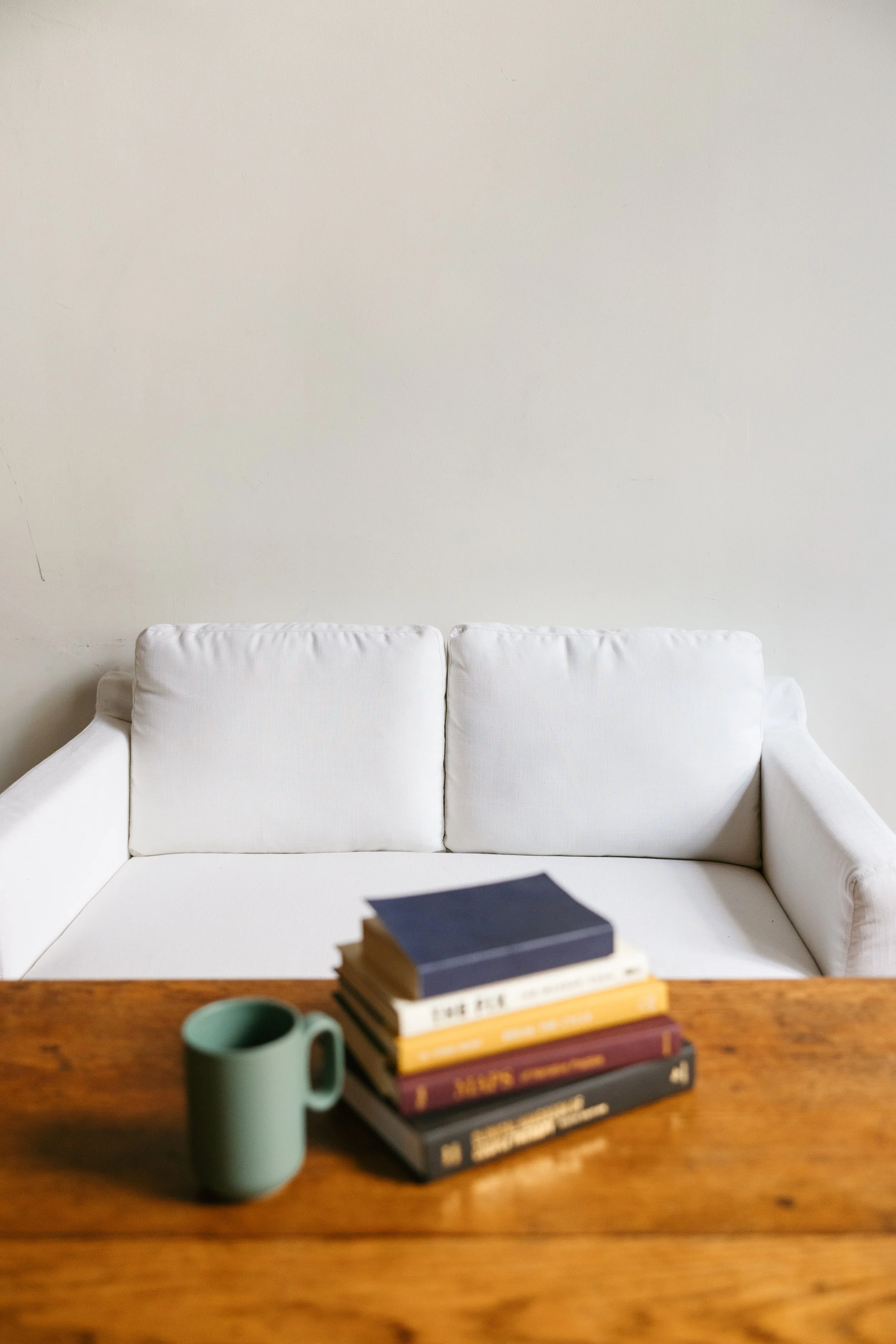 Therapy books on a table in a Nashville counseling office with a white couch in the background
