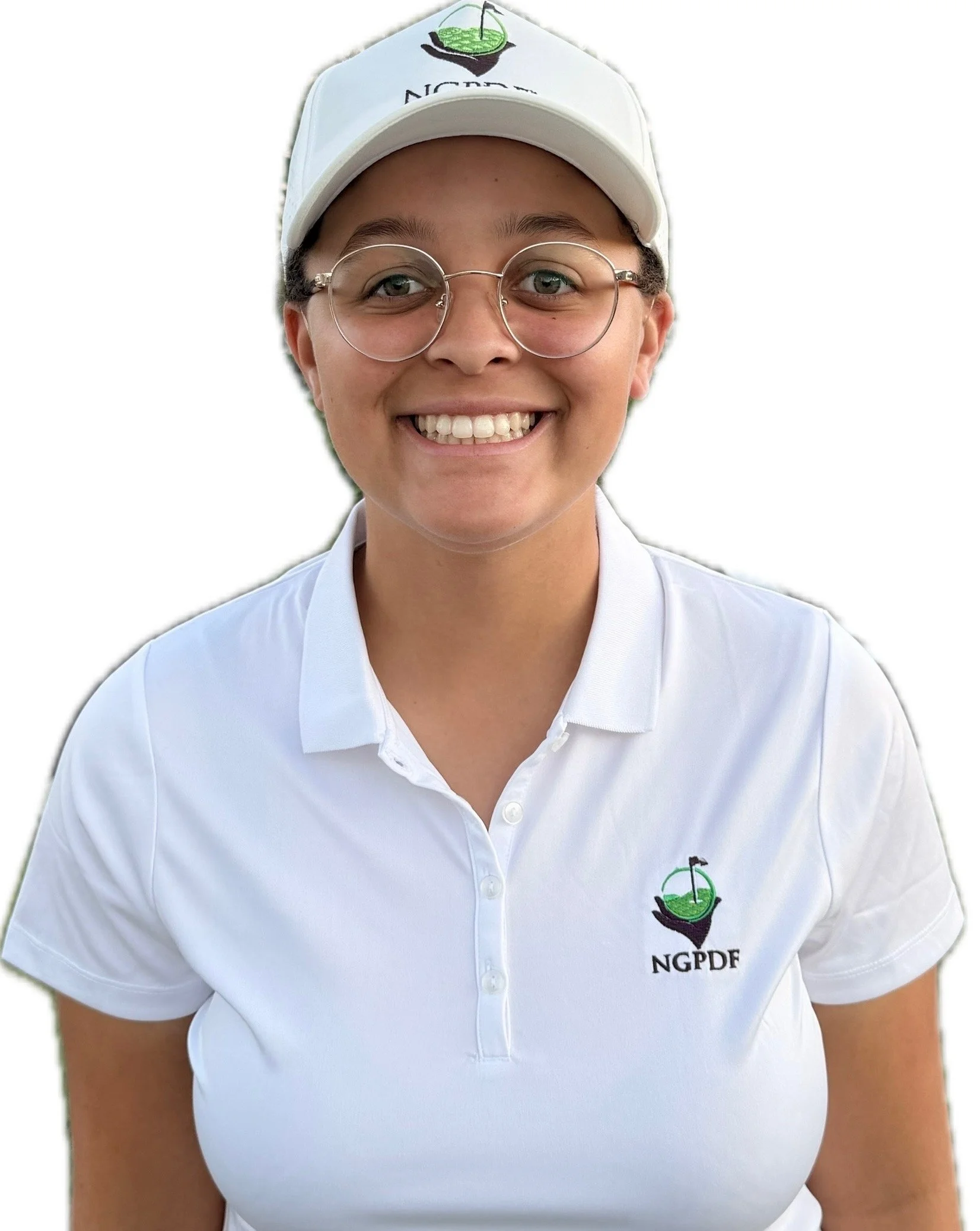 Close-up of a woman wearing a white cap and polo shirt, smiling outdoors with a grassy background.
