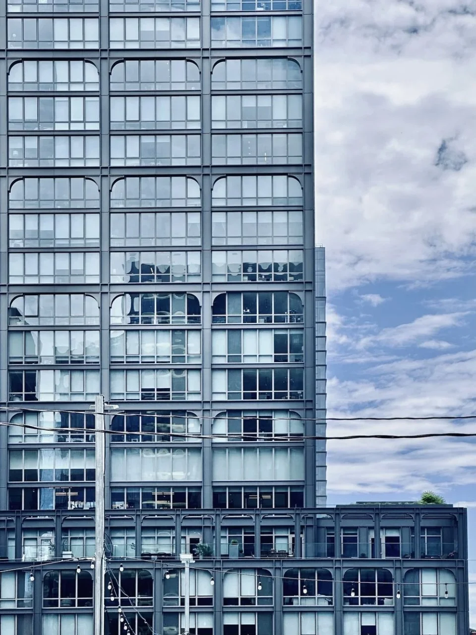 The Row Fulton Market by Morris Adjmi Architects, its dark metal frame and brick podium in Chicago's West Loop.