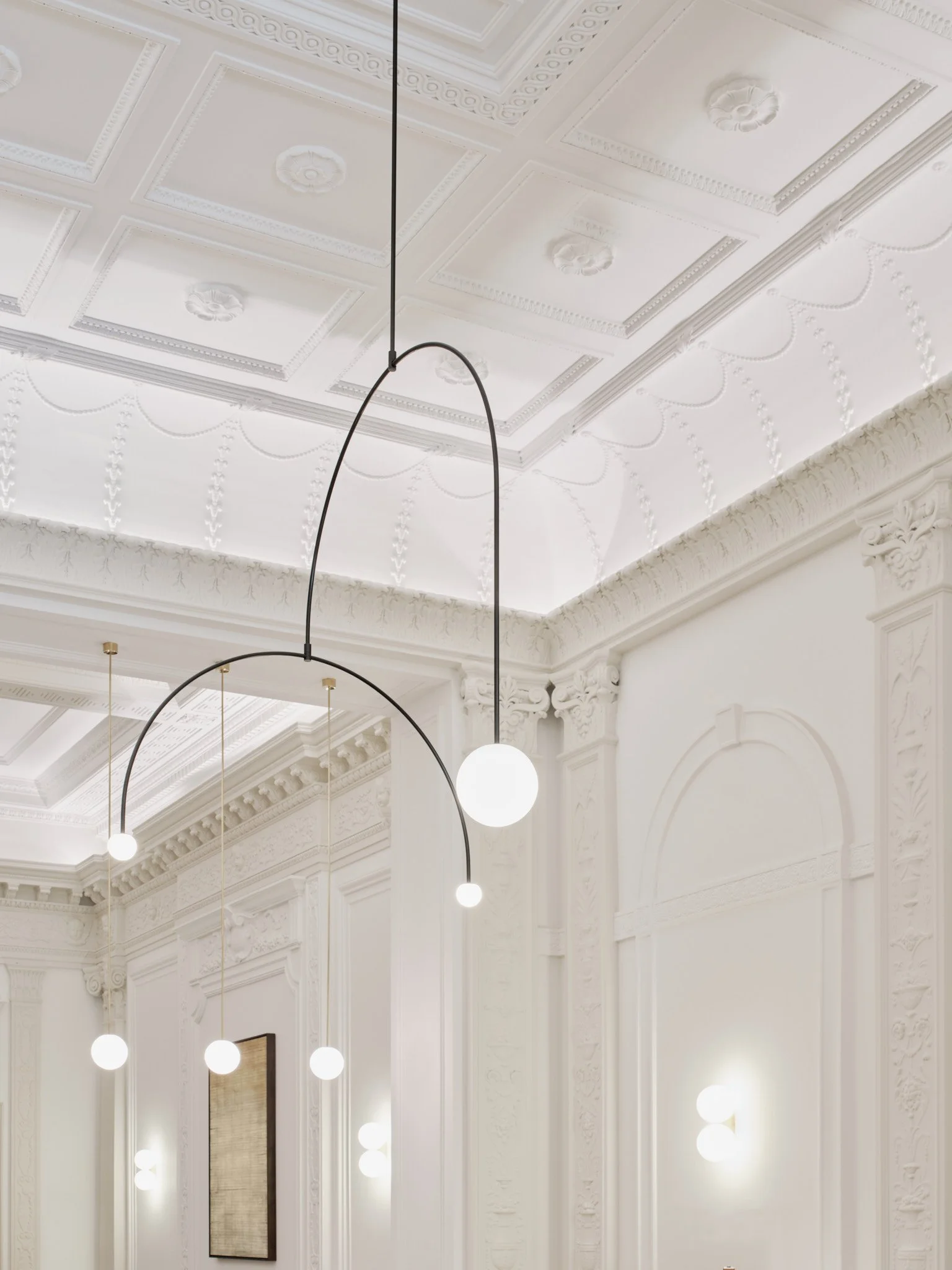 An elegant Calder like mobile replaces the solid pendant that once blocked views of the ornate ceiling.