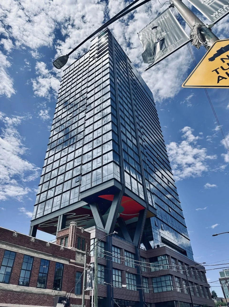 The Dylan on a brick warehouse-style base matching the low industrial buildings beside it in the West Loop.