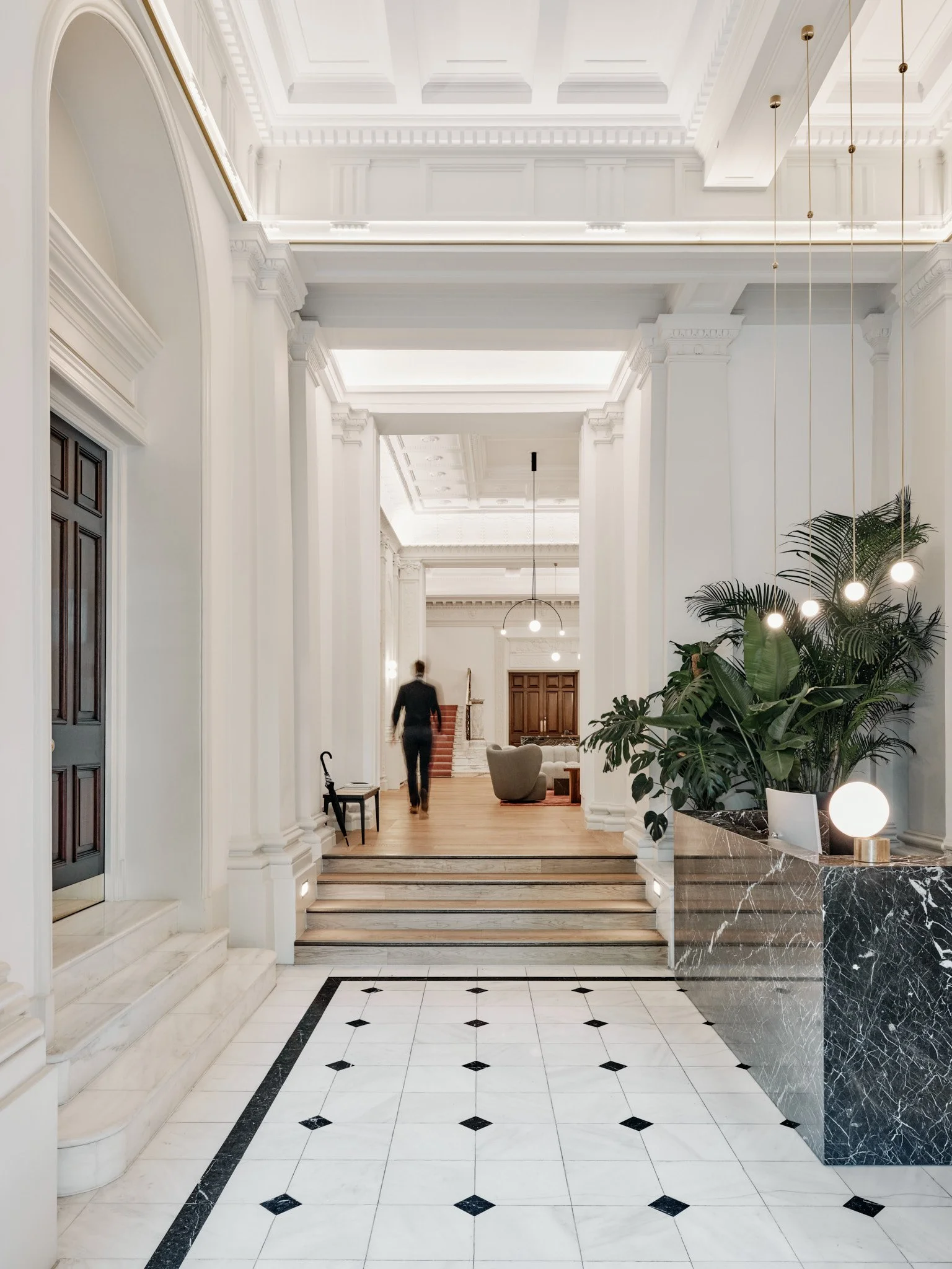 A new black marble reception desk now sits at the front entrance, lit by new cove lighting concealed by a new brass crown-like ring.