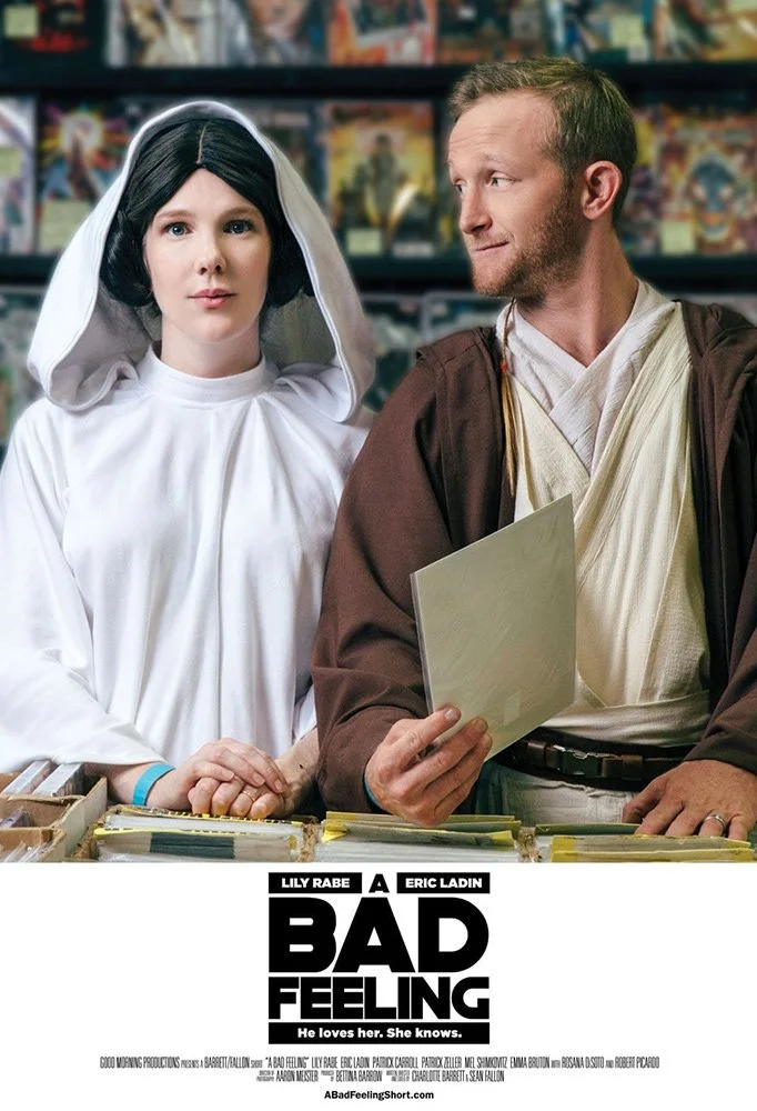 A woman dressed as Princess Leia from Star Wars and a man dressed as Obi-Wan Kenobi from Star Wars, standing behind a comic book store counter on the poster for the film 'A Bad Feeling.'
