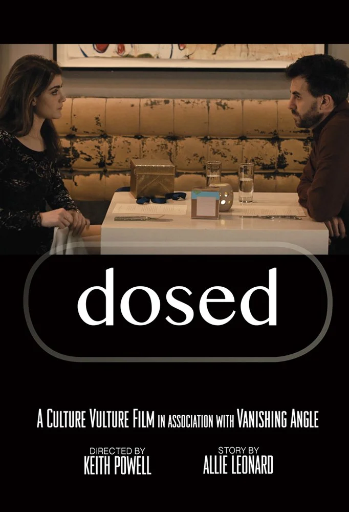 Poster for the movie 'dosed.' A woman and a man sit across from each other at a restaurant table, looking at each other with serious expressions, with drinks and a small box on the table.