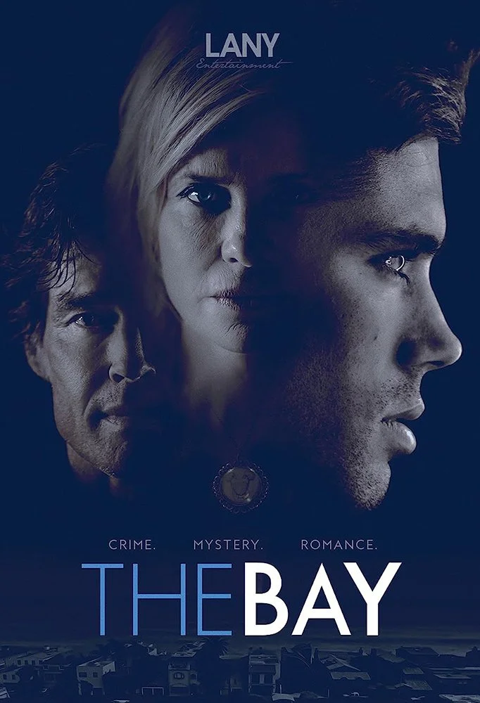 Promotional poster for the TV series 'The Bay' featuring three faces of main characters, with the tagline "Crime. Mystery. Romance." and a dark coastal background.