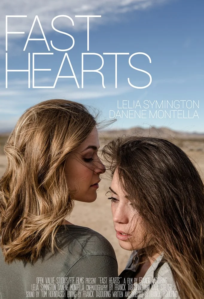 Two women in a desert landscape with blue sky, close-up, faces almost touching, with the title 'Fast Hearts' and credits.