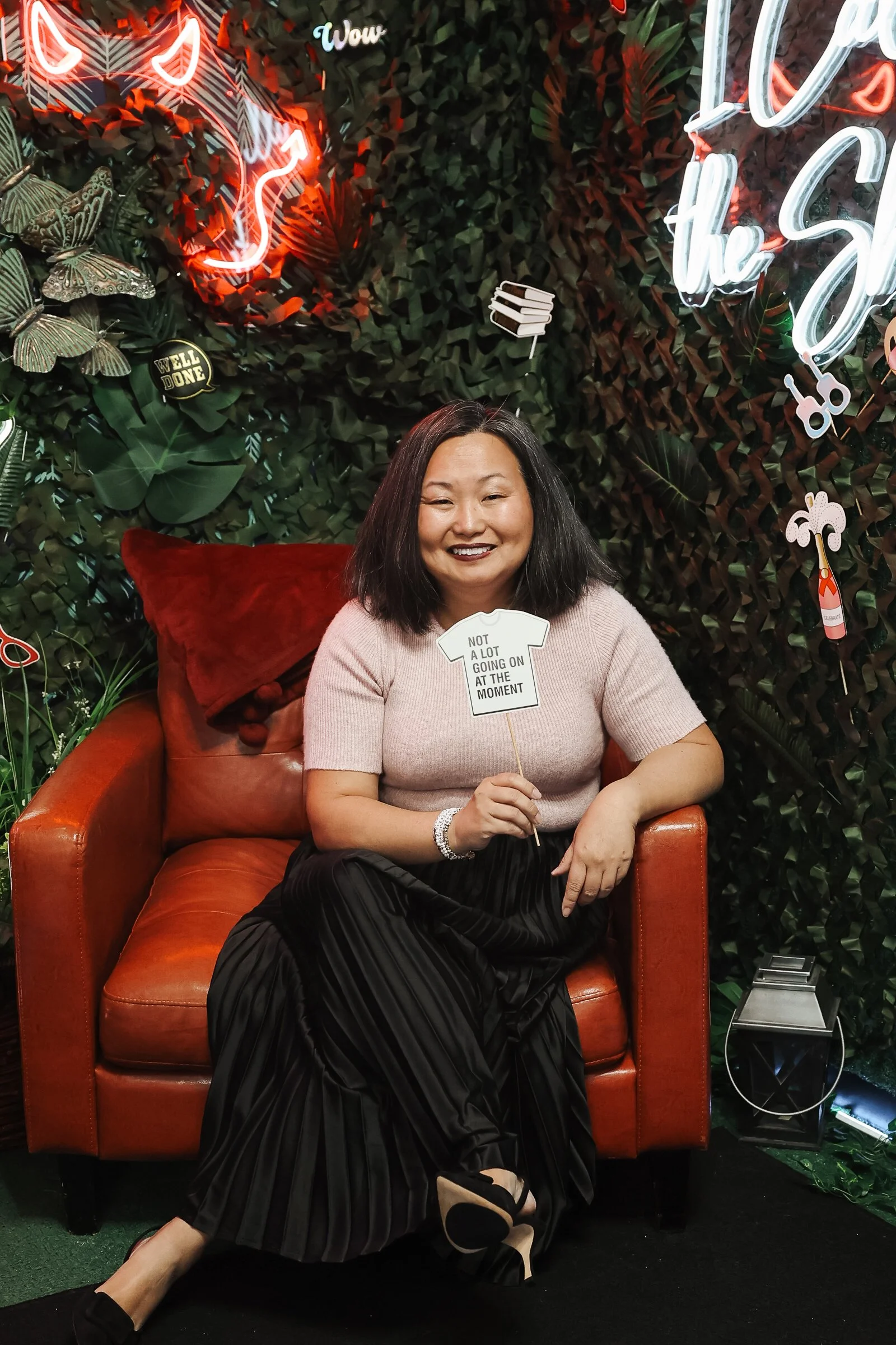 Photo of asian woman sitting with a sign saying "alot going on at the moment"