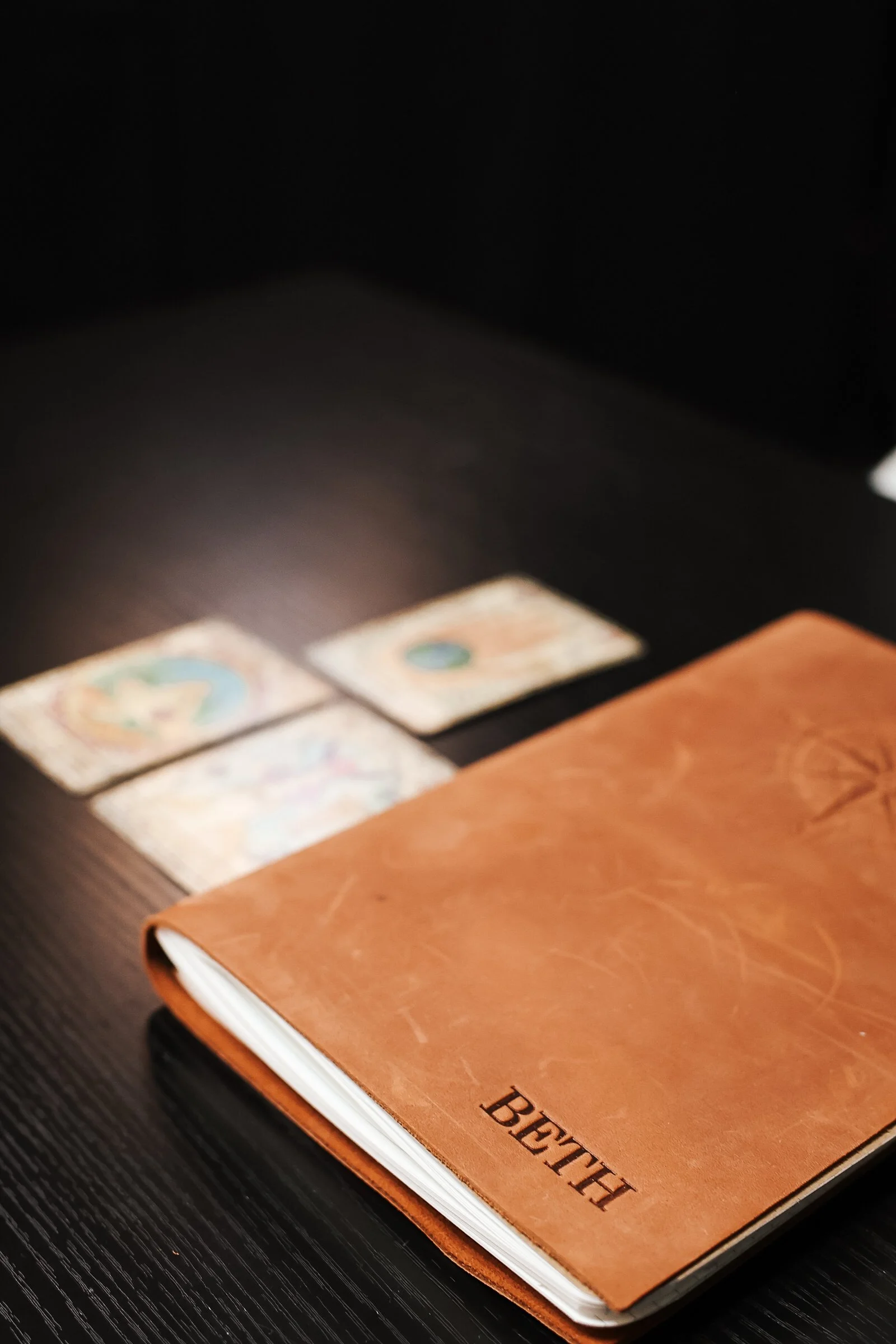 Leather notebook with BETH on it and 3 tarot cards