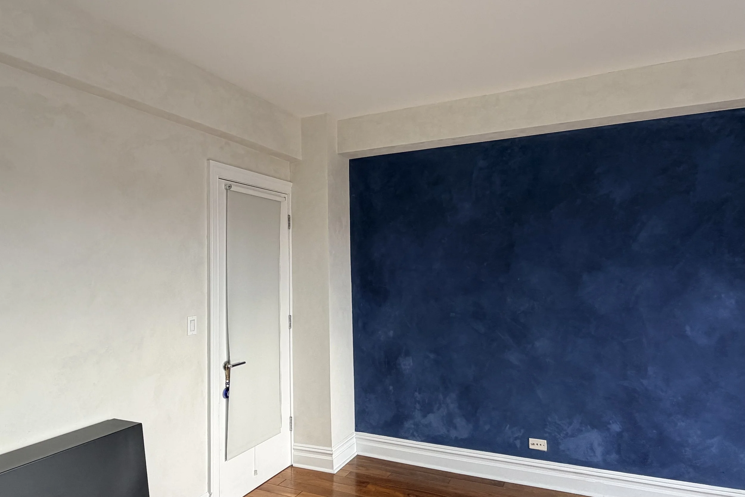 Navy accent wall with cool gray limewashed surrounds and doorway — West Village bedroom, Limewall & Co.
