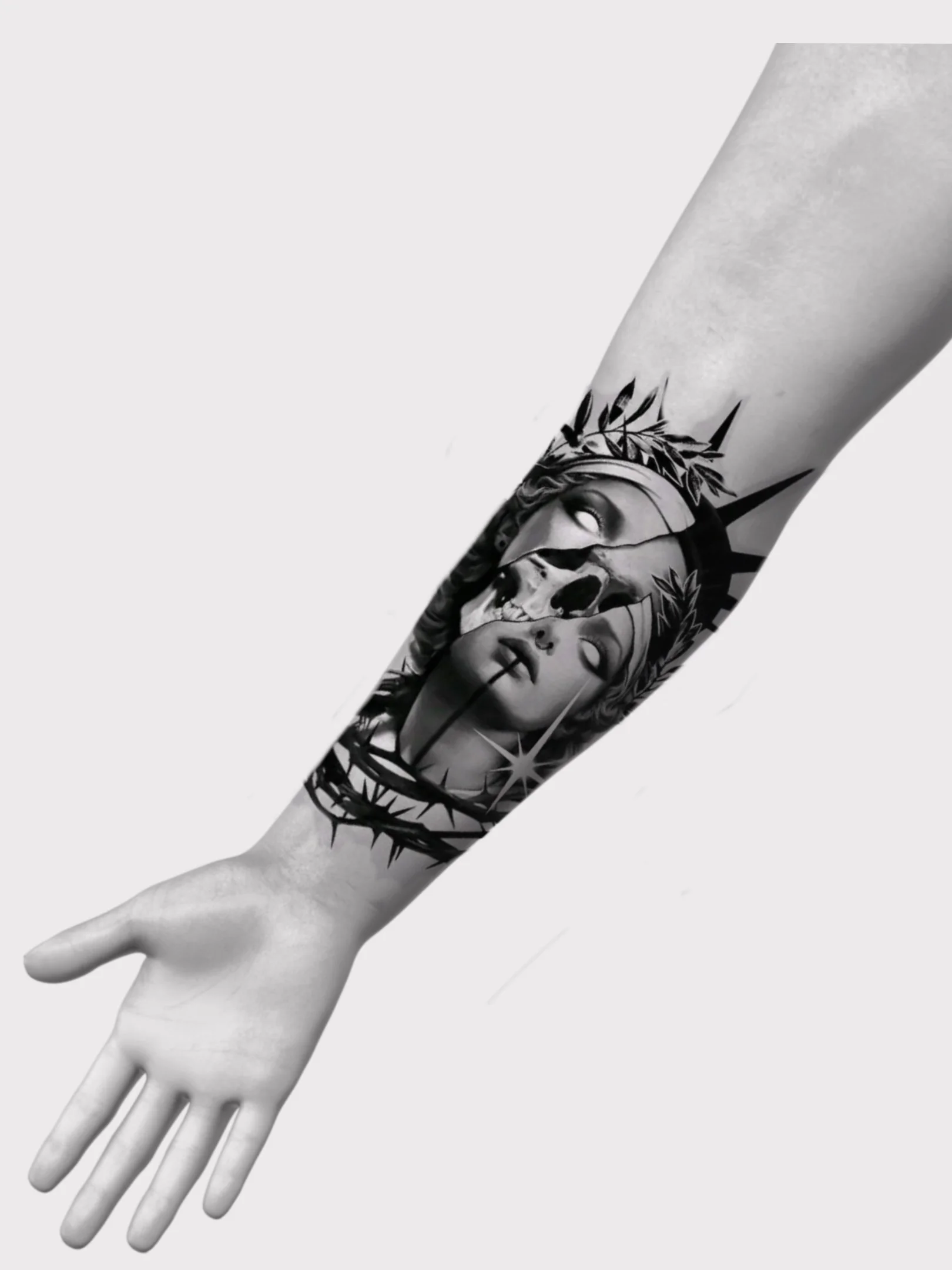 Black and gray tattoo of a woman's face with a crown and laurel leaves, a skull, and starburst details on a person's forearm.