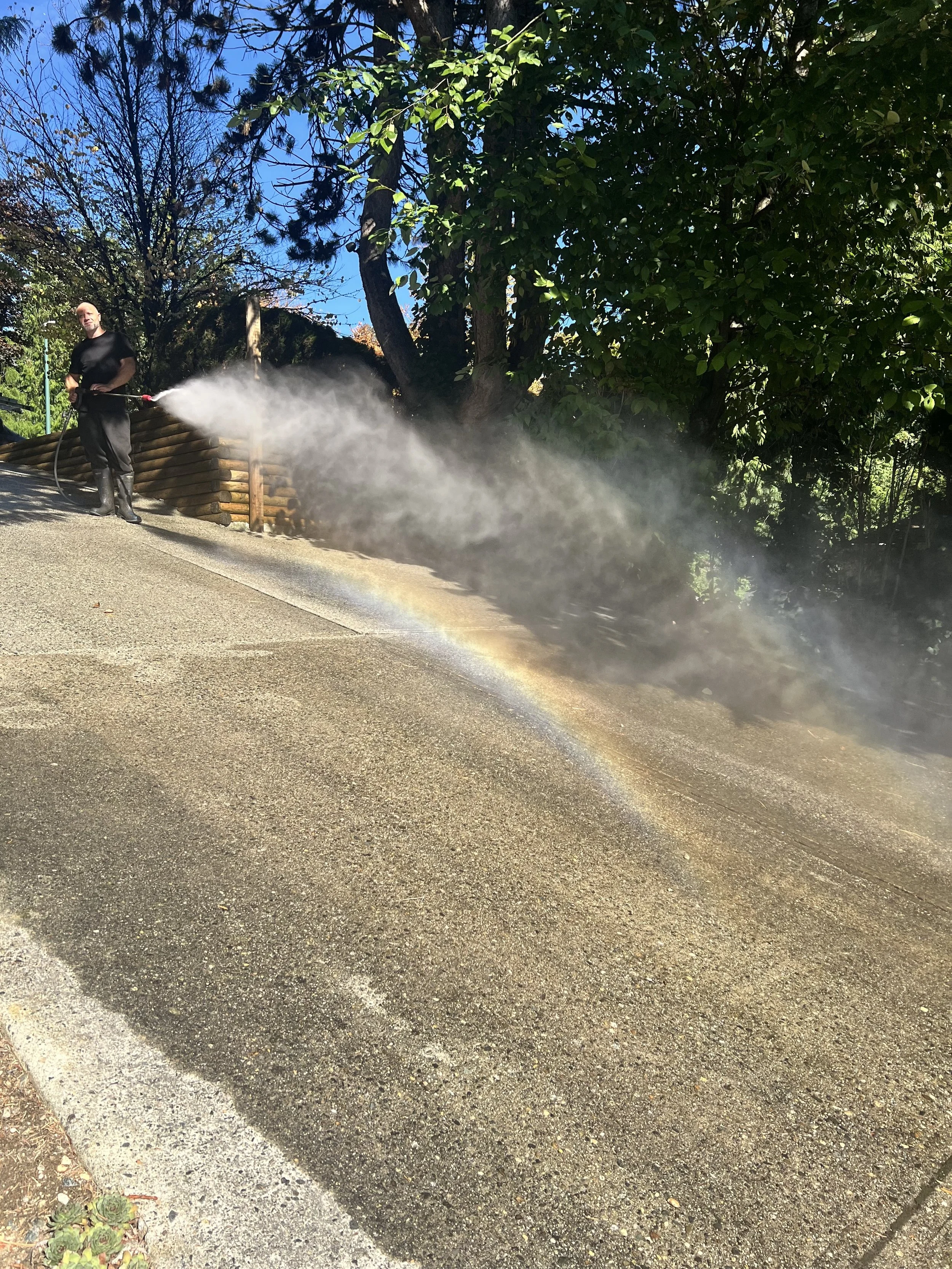 Man with pressure washer spraying water into air
