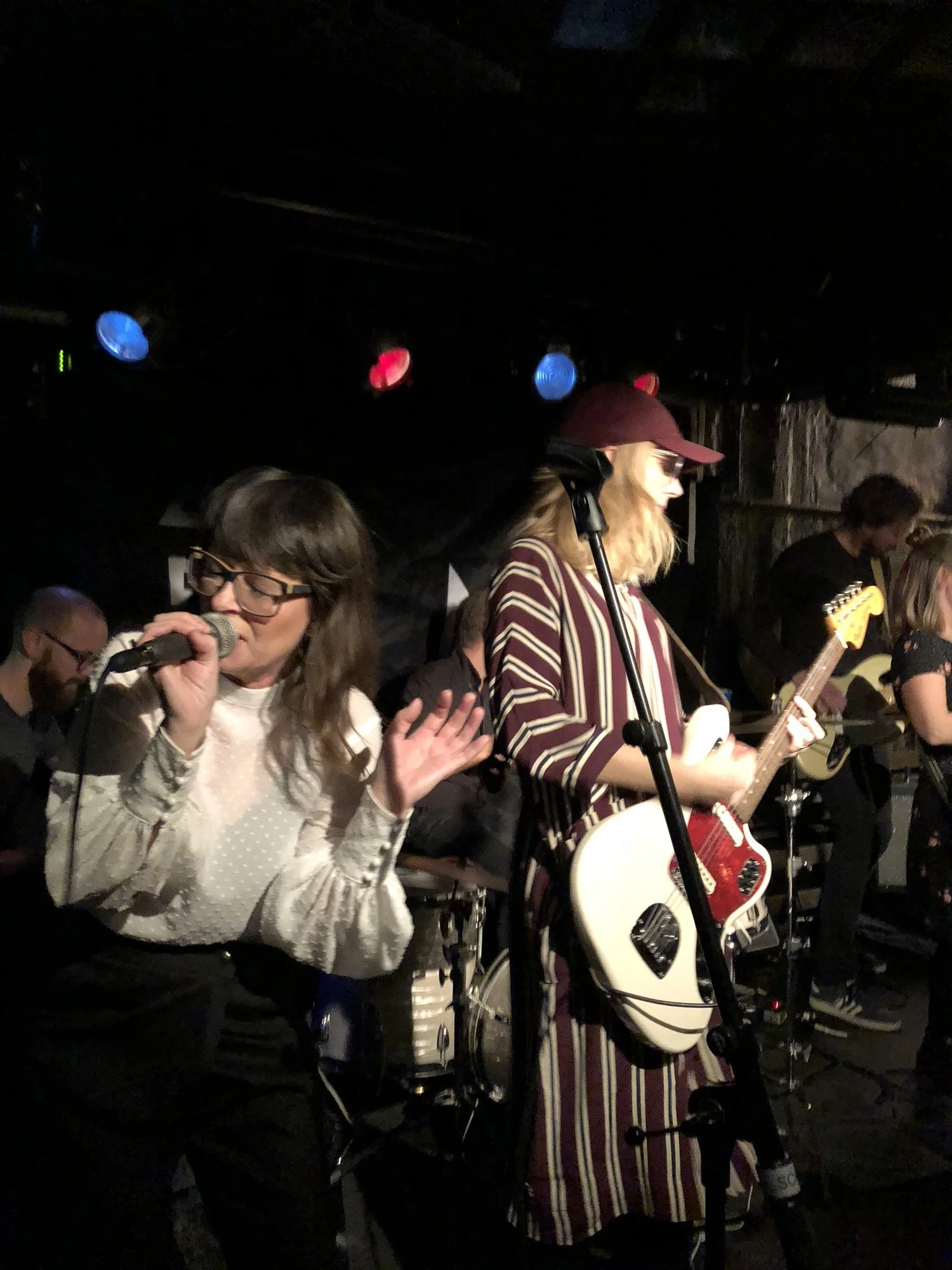 Bilden visar 500 mil under en konsert på Scalateatern i Stockholm. En vitklädd Anna Charlotta sjunger och Christel spel gitarr. Hon bär röd keps och rödrandig skjorta.